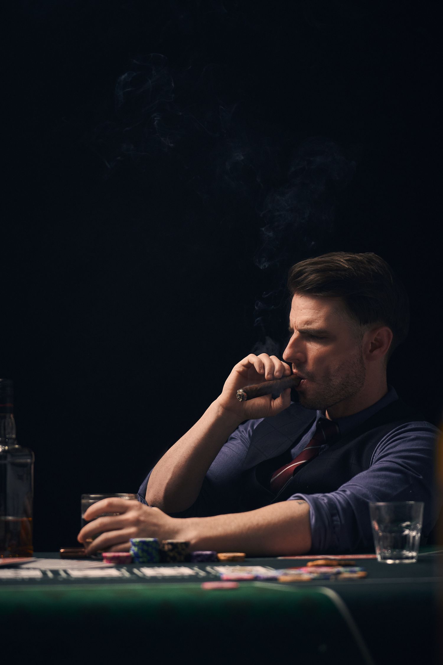 Man playing poker with cigar.