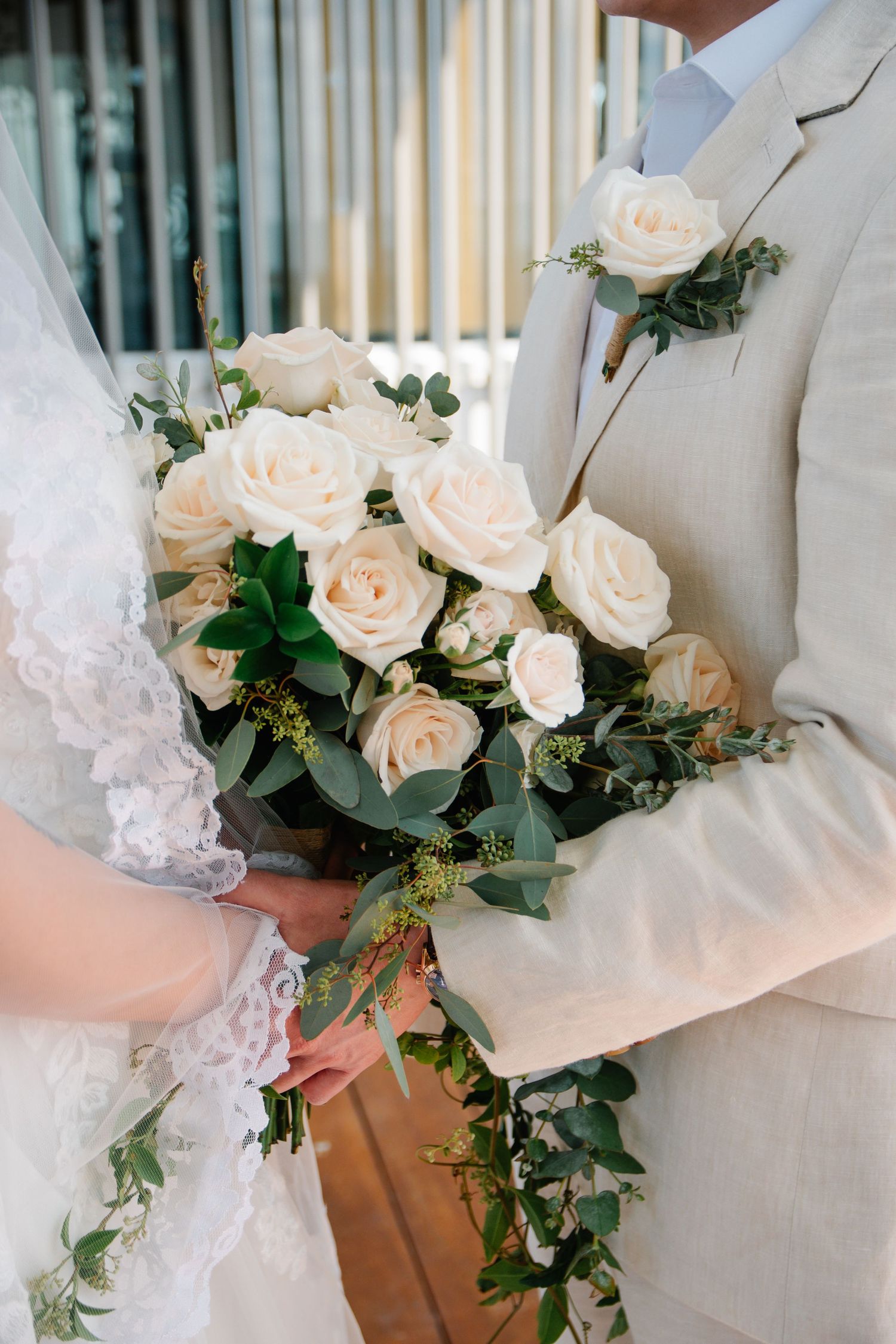Close-up of white roses and greenery in wedding bouquet.