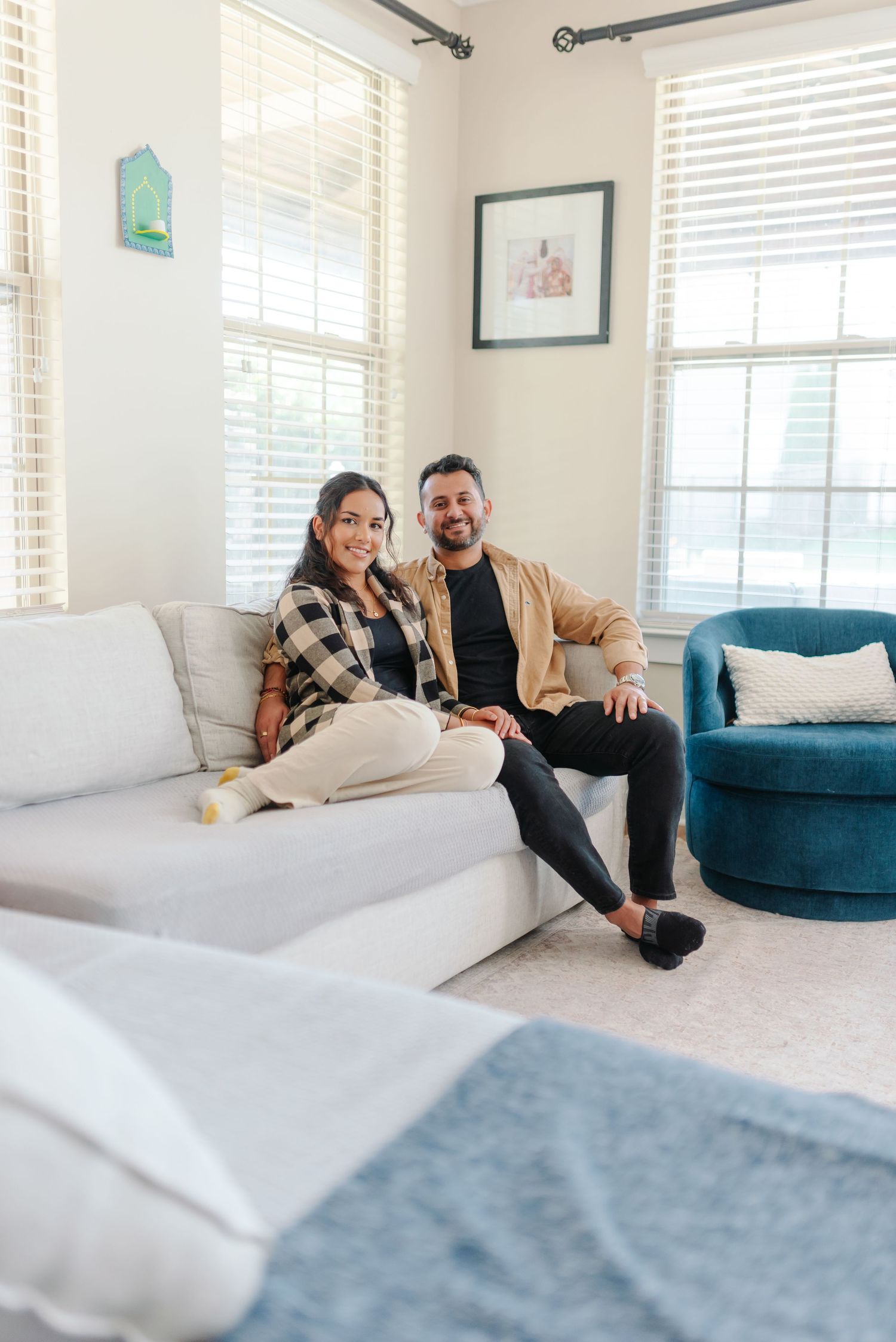 Couple relaxes together on white and blue furniture in a bright modern living room.