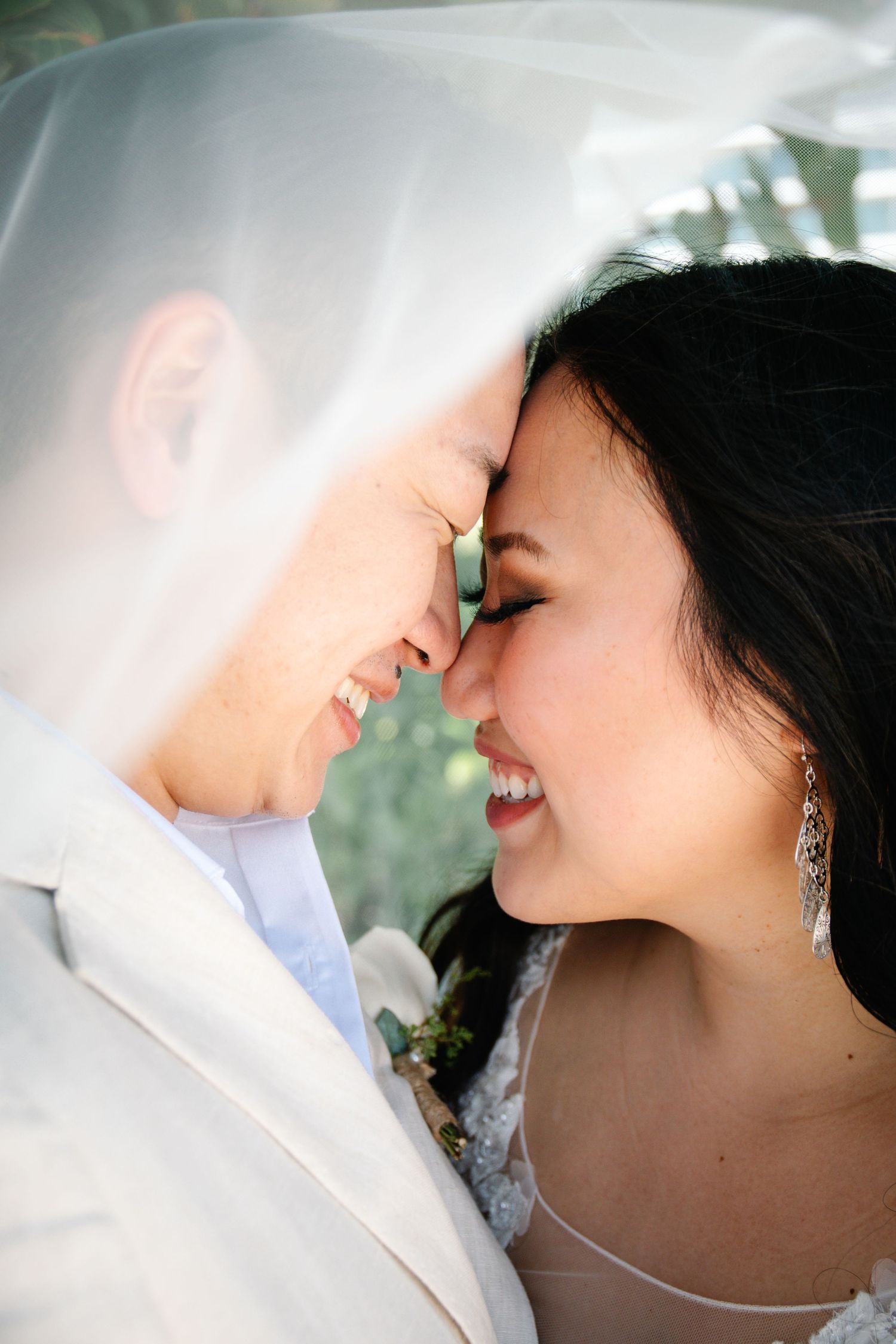 An intimate moment between newlyweds under a delicate white veil.
