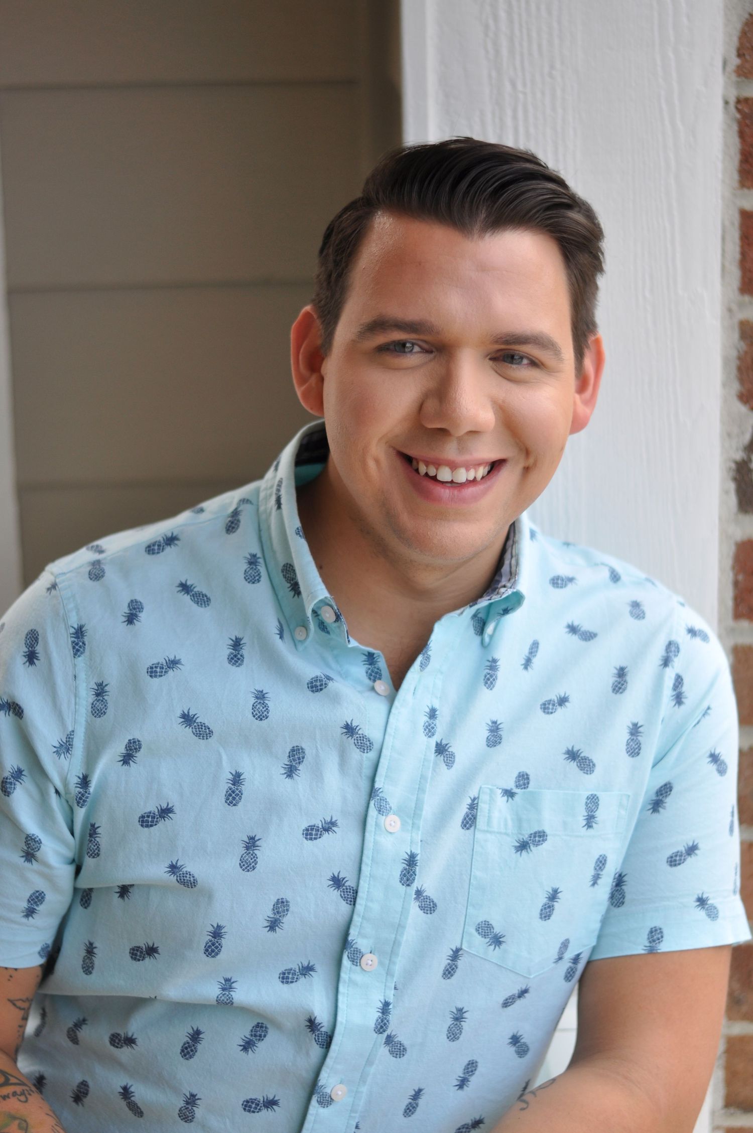 Portrait series in light blue patterned shirt against white background.