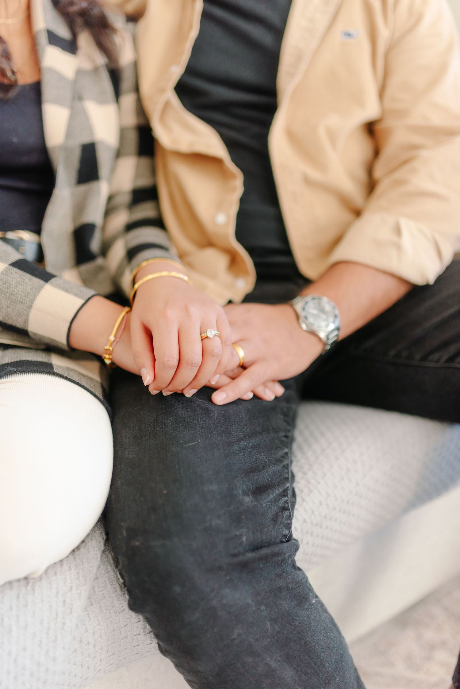 Close-up shot of hands resting on legs wearing casual attire.