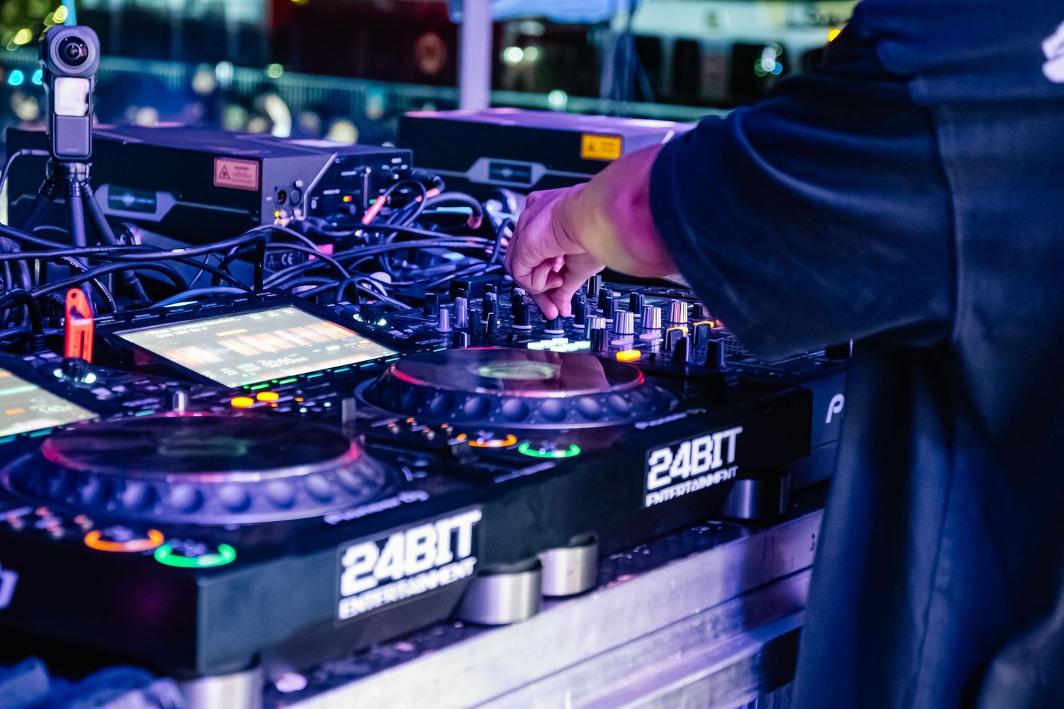 Professional DJ setup with turntables and mixing equipment under purple lighting.