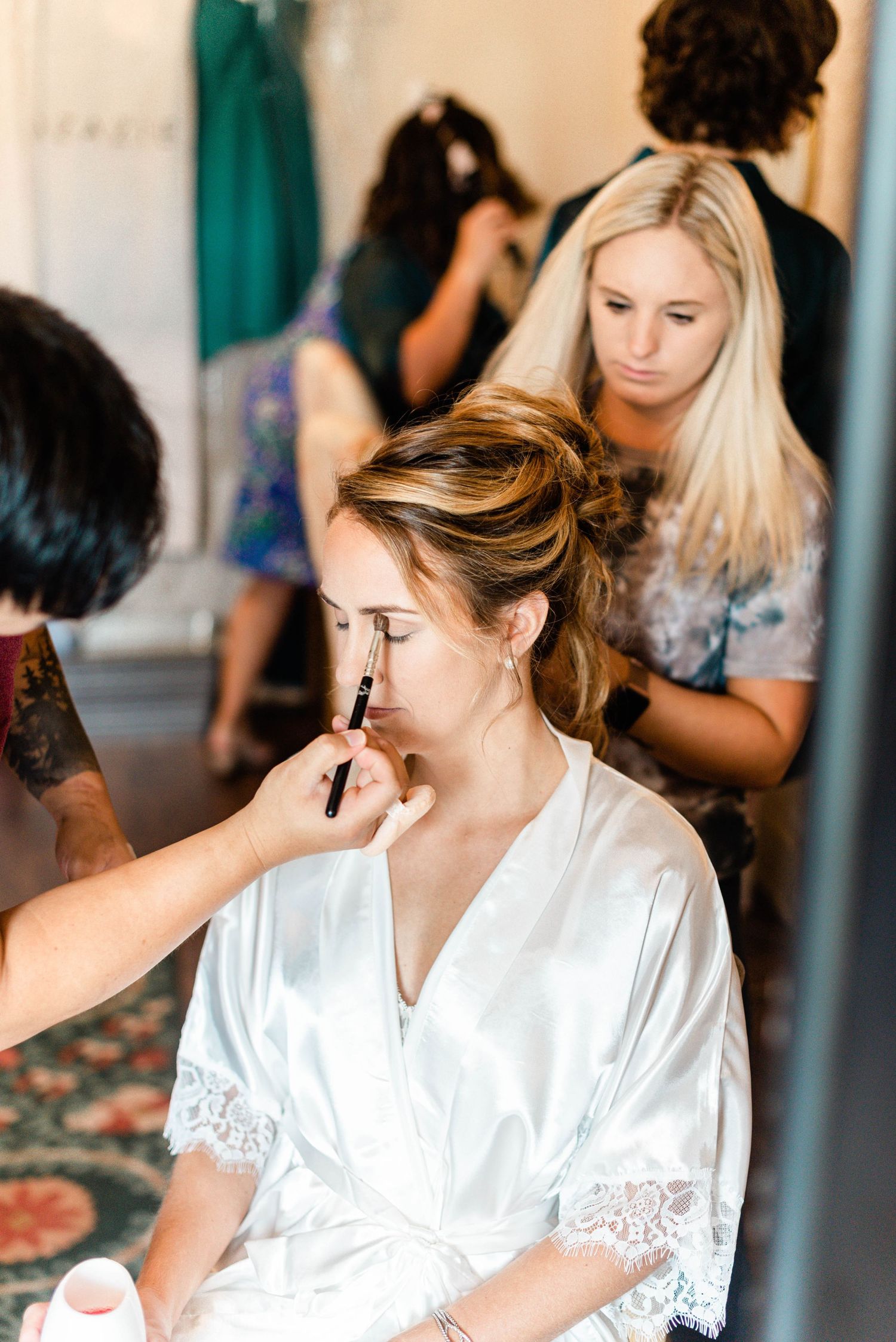 Behind-the-scenes shots of bridal makeup preparation in a getting-ready room.