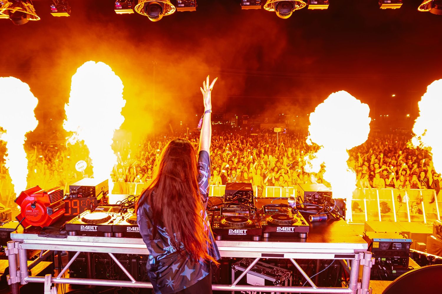 Concert stage with intense orange flames and pyrotechnics lighting up the performance.