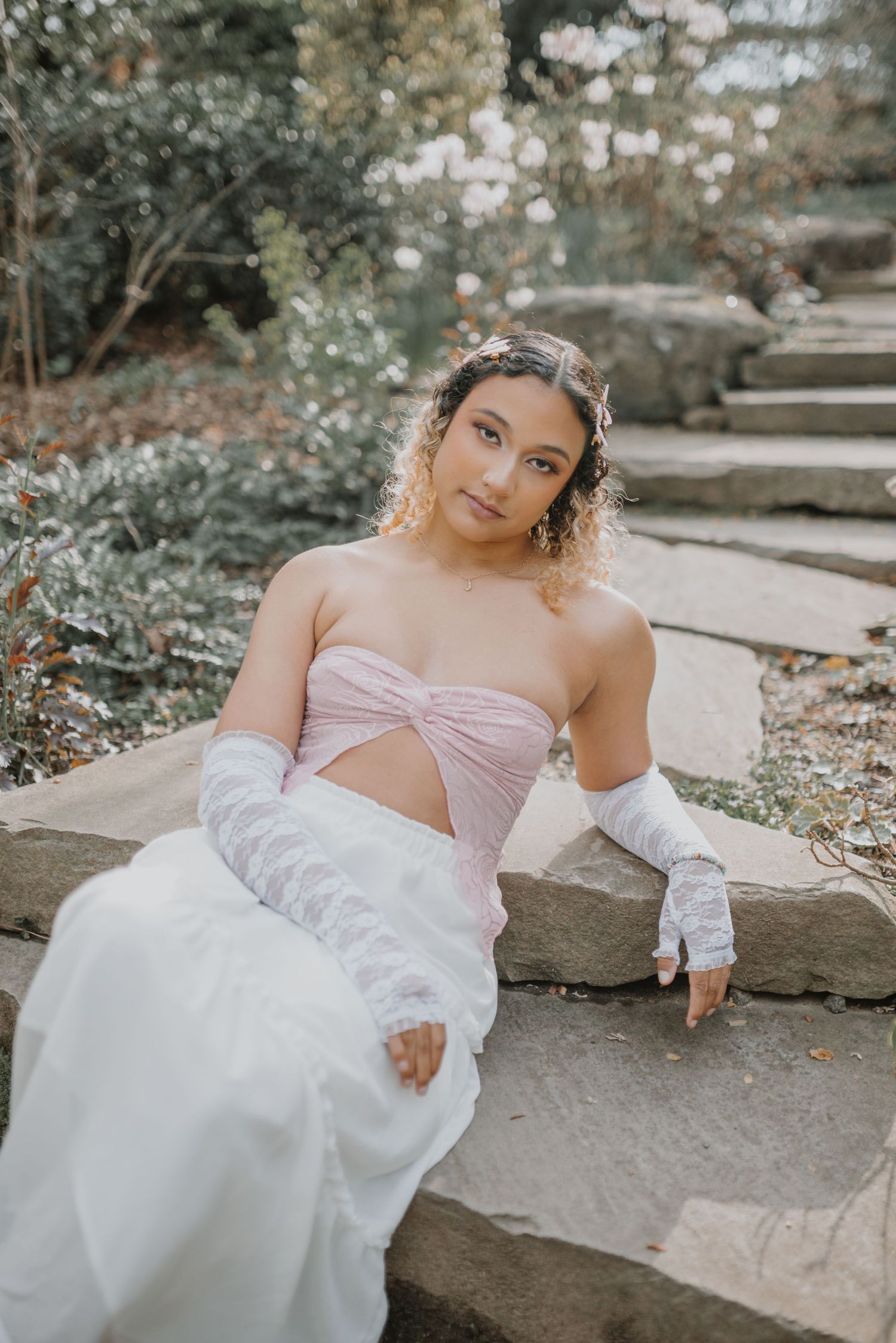 Romantic bridal portrait on stone steps in garden setting.
