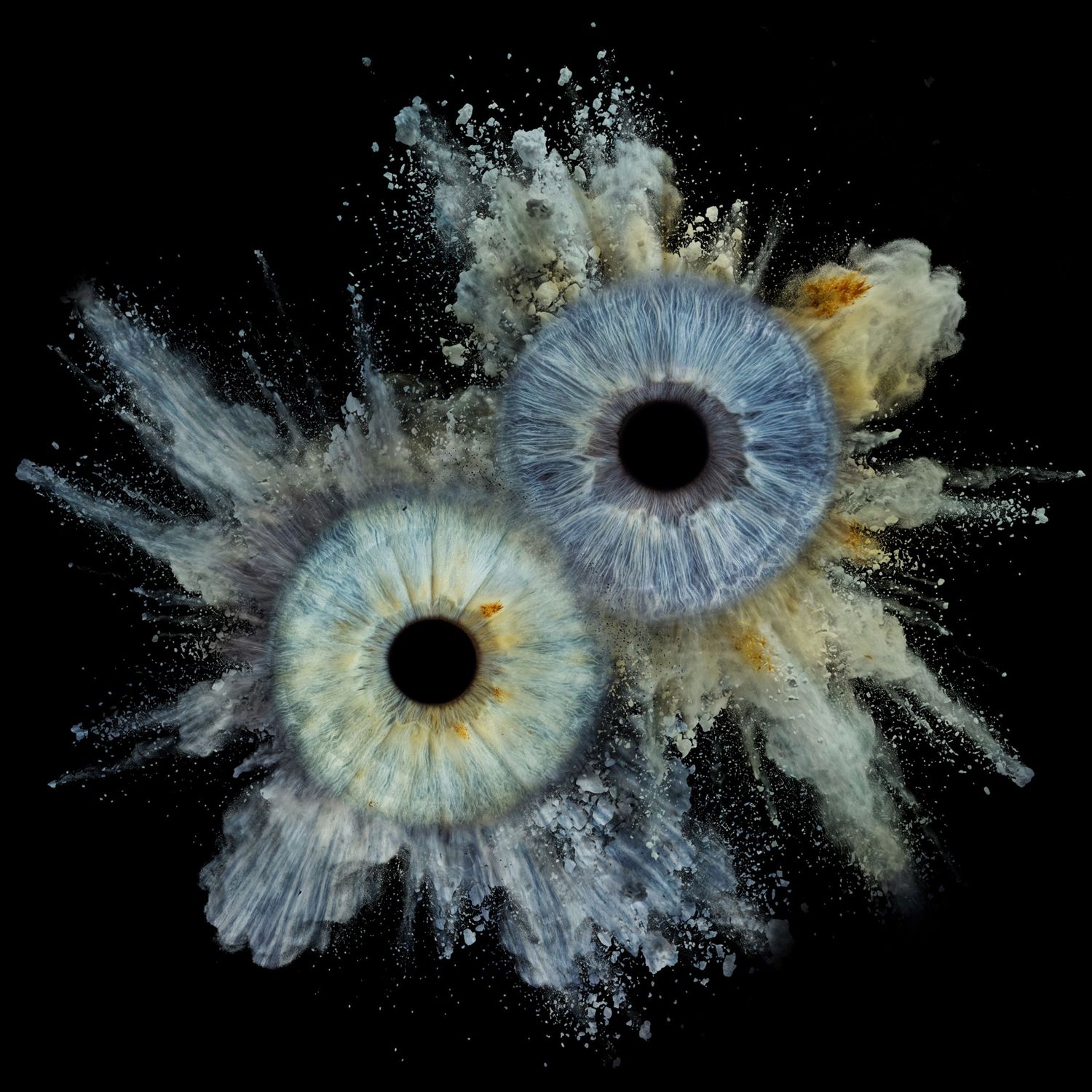 Two blue-green human eyes exploding with powder dust on black background, surreal macro photography art.