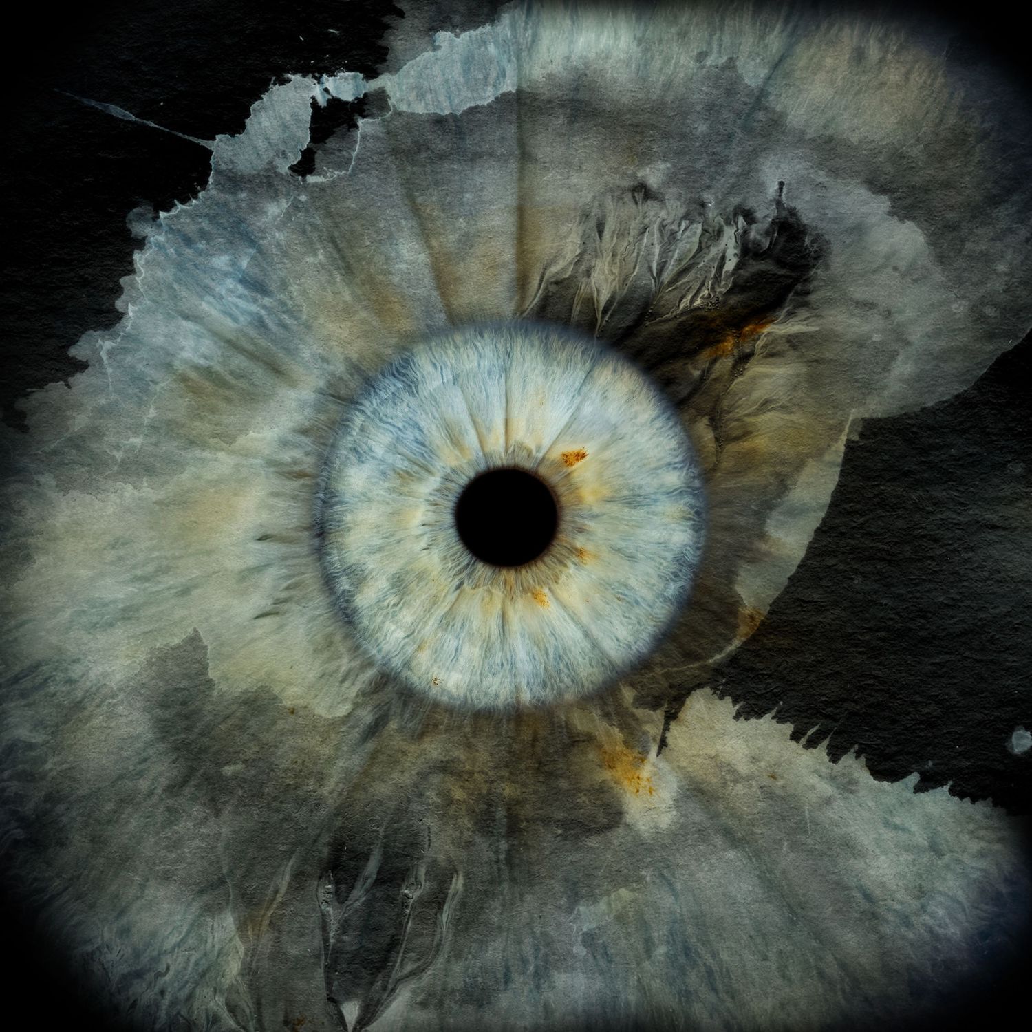 A dramatic macro shot of a blue human iris blending into torn paper-like texture with dark watercolor splashes.