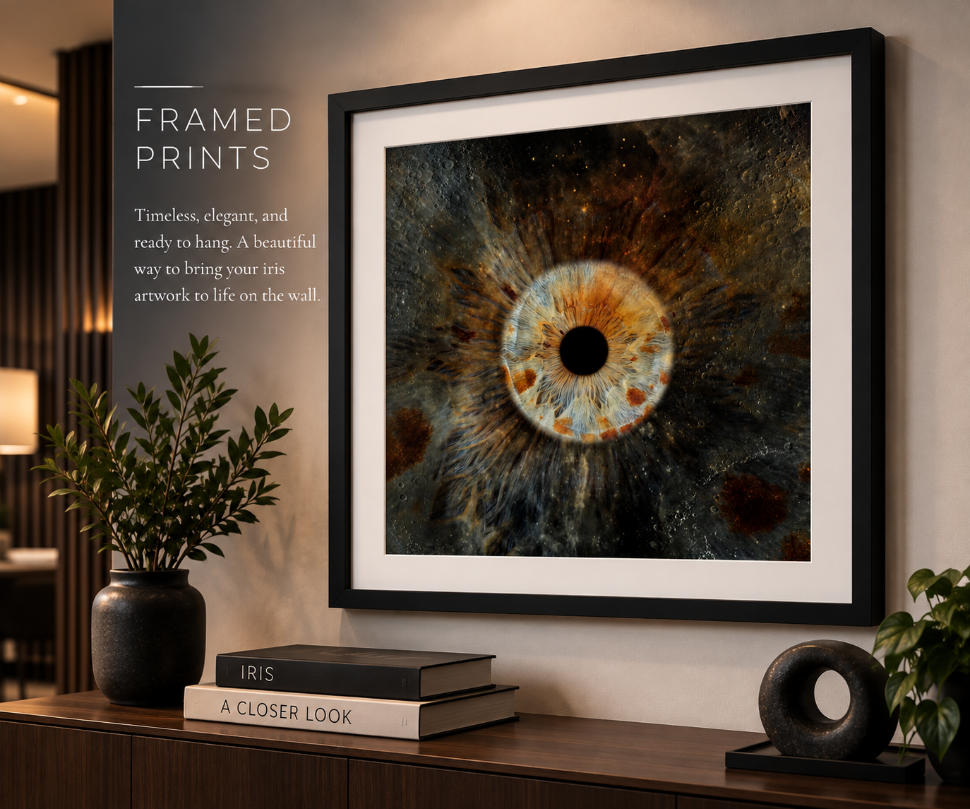 Framed print of a macro eye artwork in dark tones, displayed on a wall above a wooden console with books and decor.