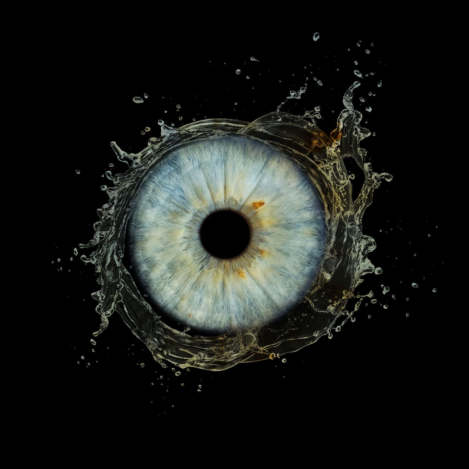 Stunning macro photo of a blue human eye iris emerging from a dynamic water splash on black background.