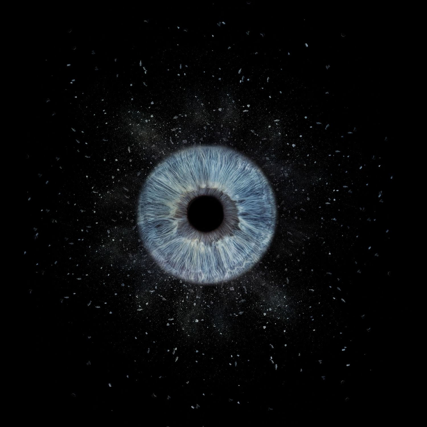 A blue human iris surrounded by scattered white particles resembling stars on black background.