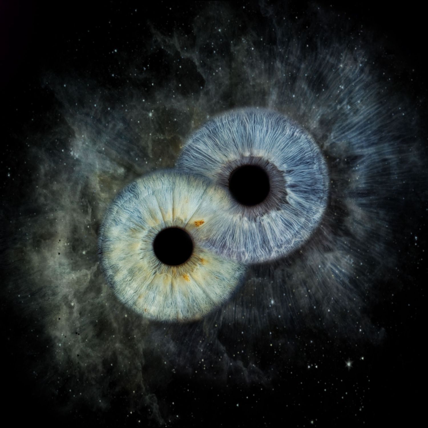 Two overlapping human irises with blue and gold tones set against a dark cosmic starfield background.