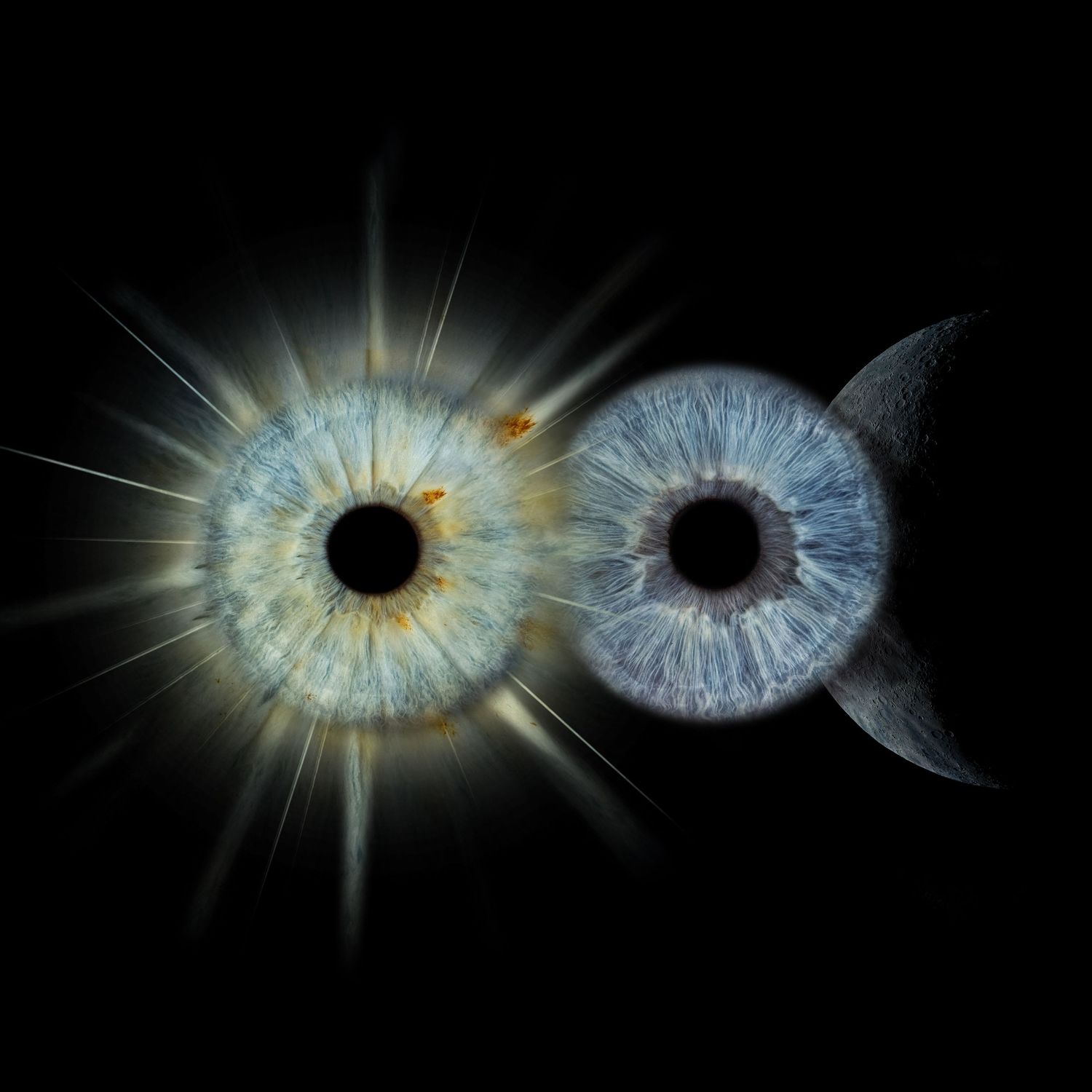 Two human eyes with blue-gray irises on black background, one with sun rays, one with crescent moon artistic concept.