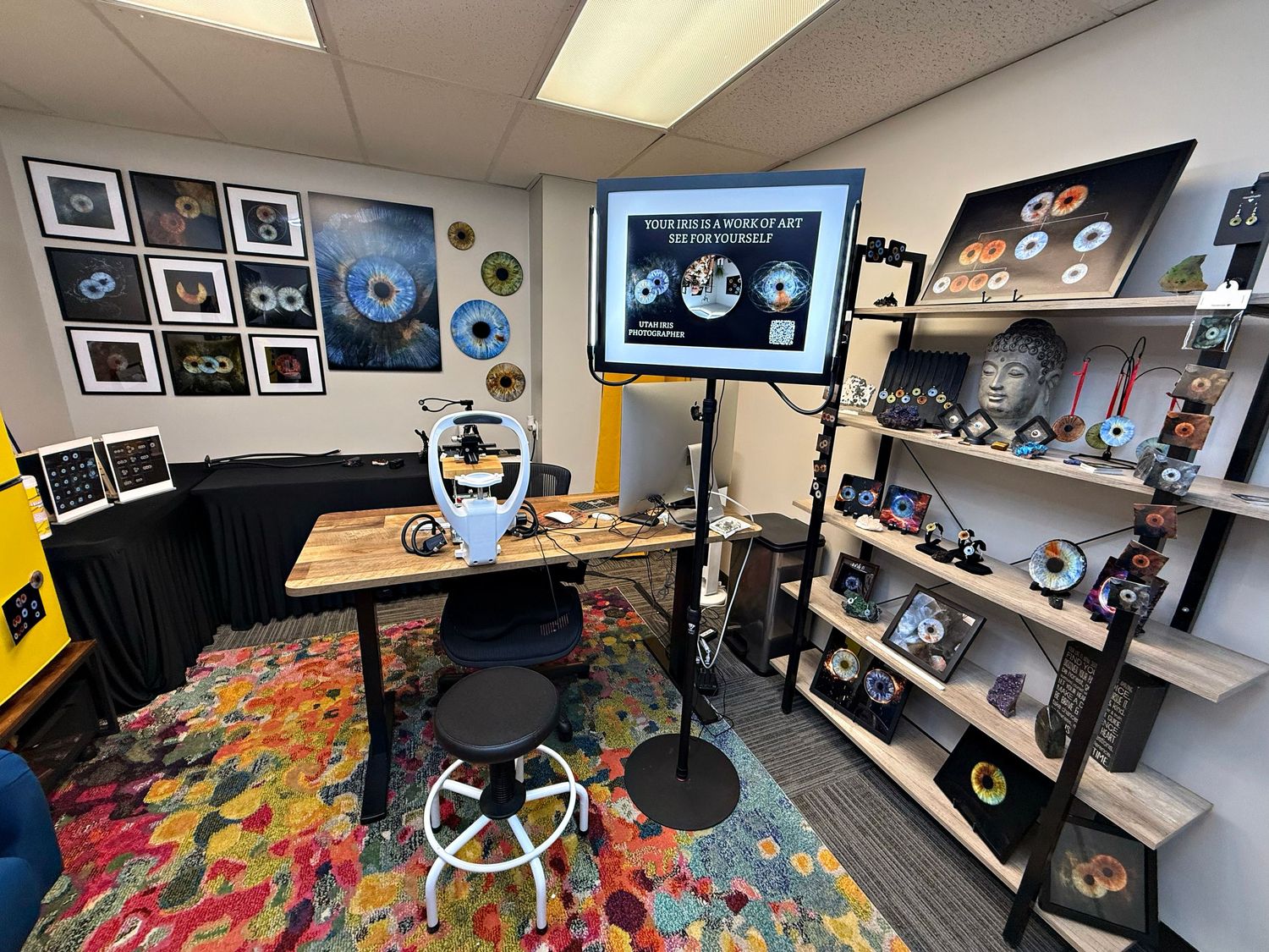 A panoramic view of a creative workspace with shelves displaying collectibles, photos, and gaming memorabilia.
