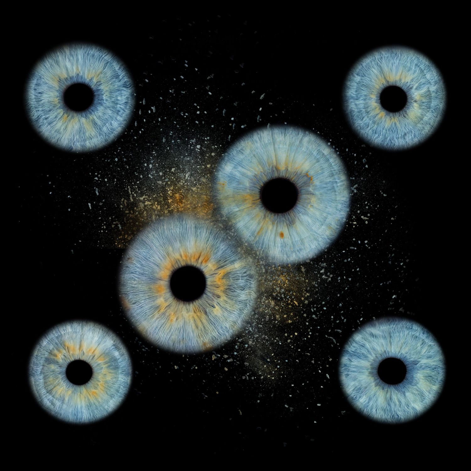 Six blue human eyes with golden centers arranged on black background with sparkling gold dust particles.
