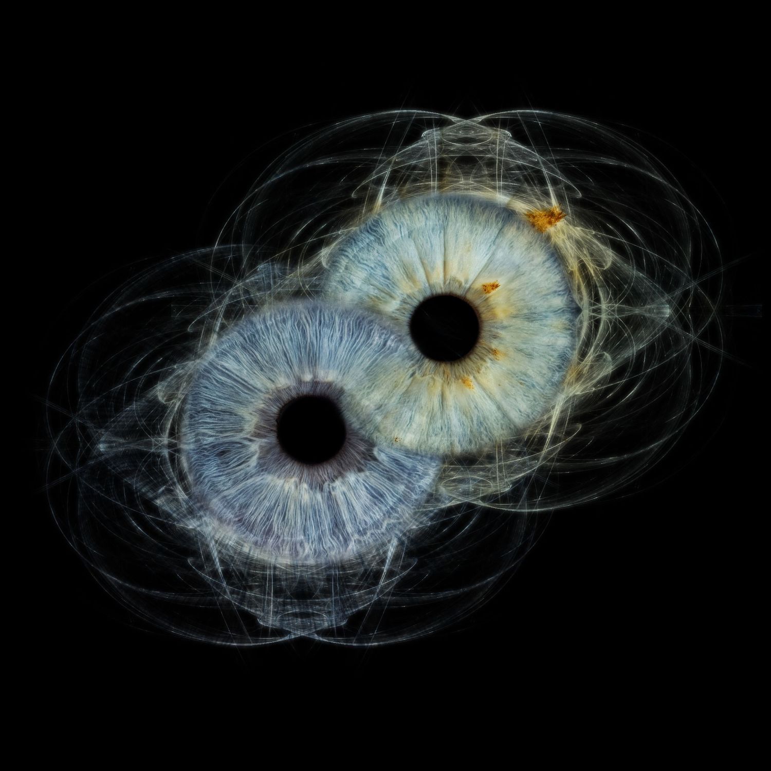 Two overlapping human eyes with blue irises surrounded by glowing fractal energy patterns on a black background.
