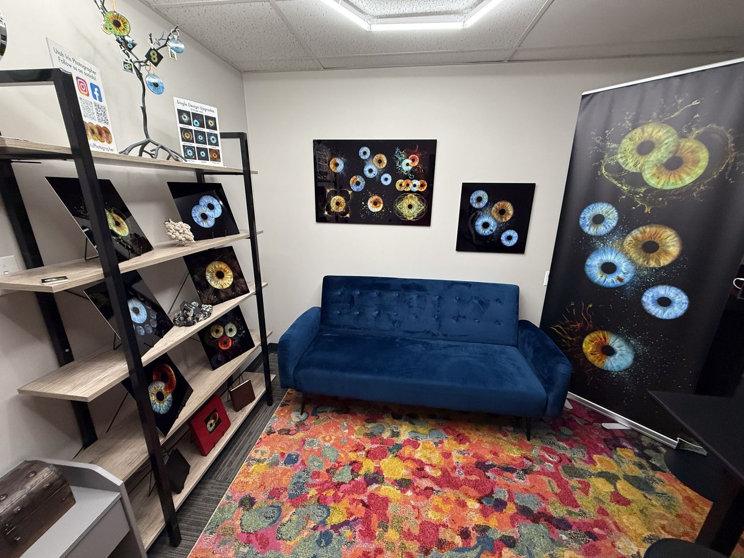 Modern room interior featuring a navy blue velvet sofa, abstract circular wall art, and a vibrant multicolored area rug.
