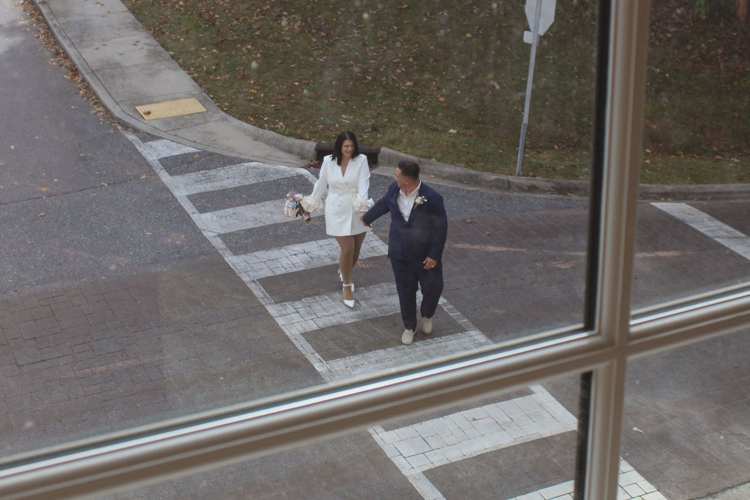 A couple walking across a cross walk, shot from inside before couple arrived for elopement session
