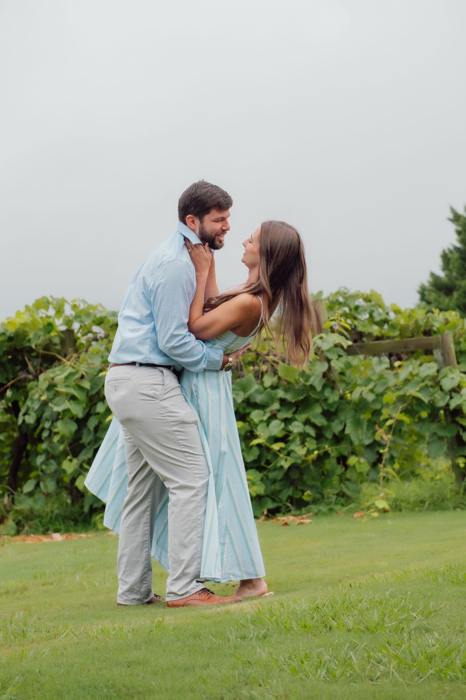 A man and woman dancing in a vineyard after their proposal
