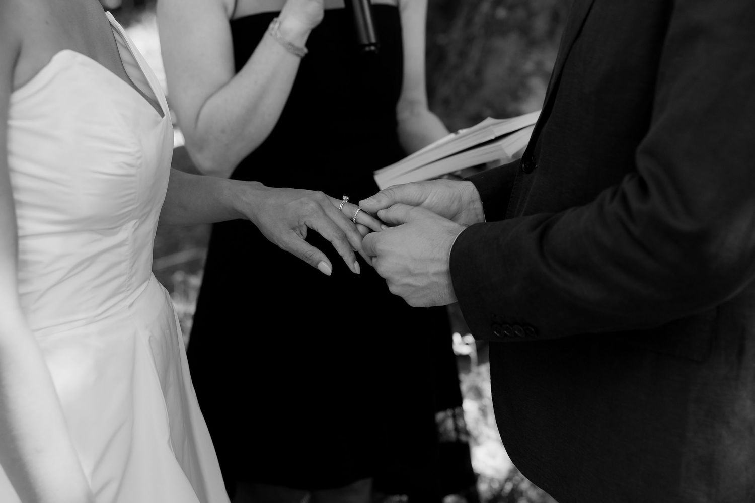 Black and white wedding ceremony moments showing exchange of rings.