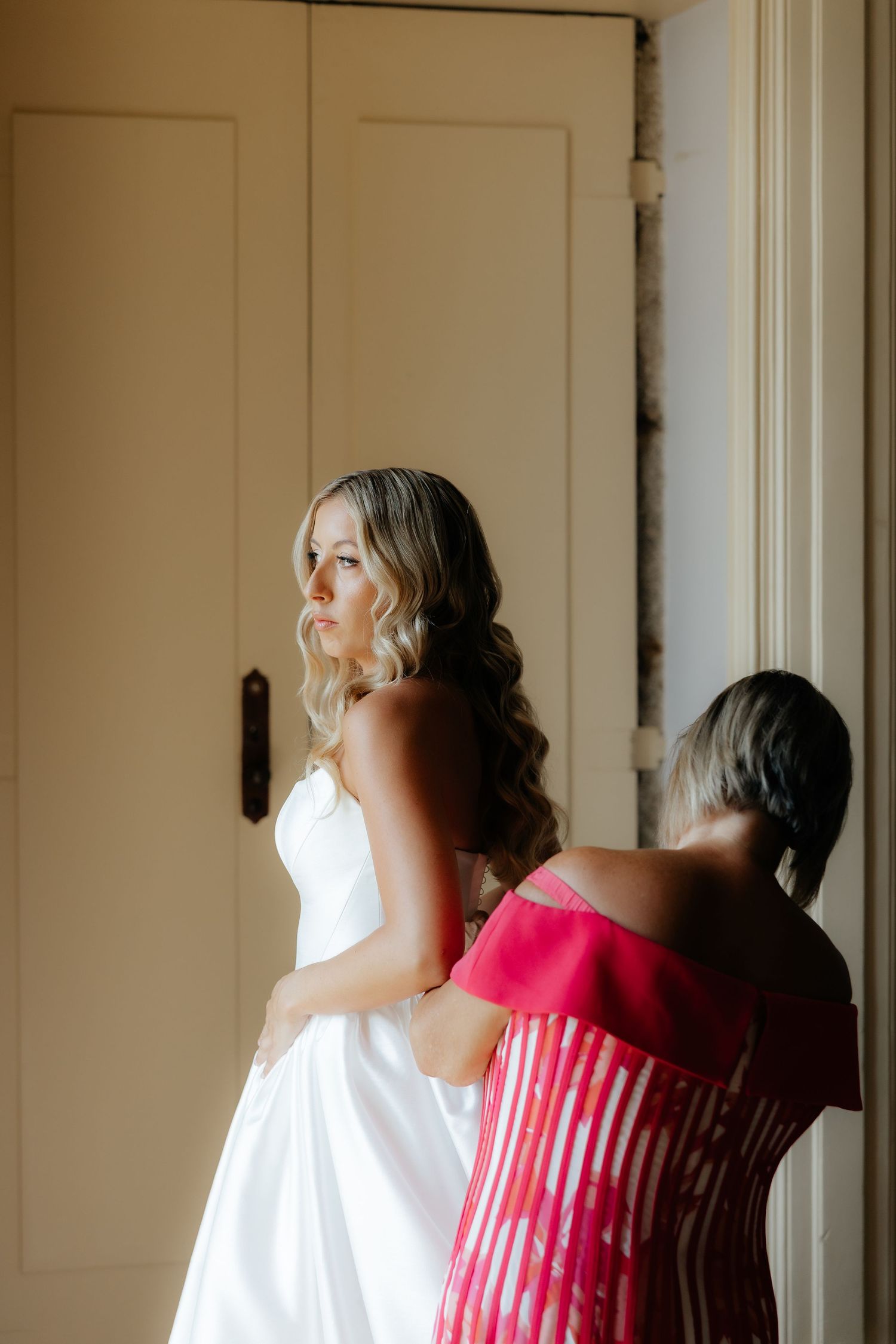 A sequence of four photos showing a person in a white robe and pink dress getting ready in soft natural light.