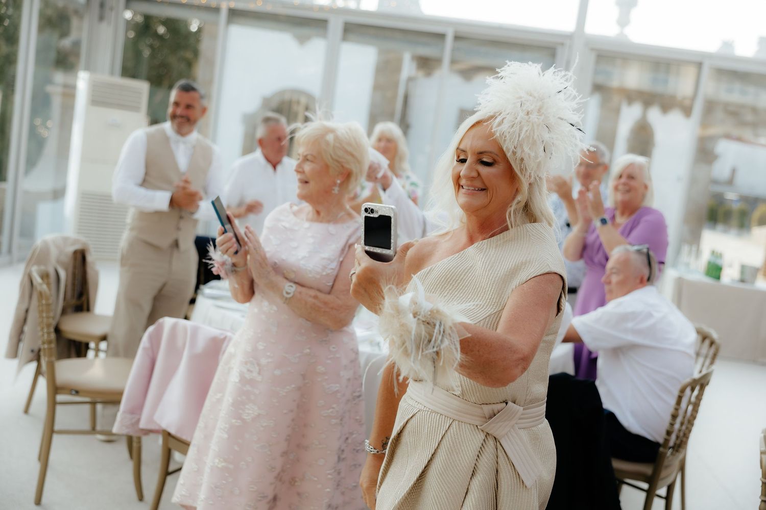 Guests dancing and celebrating at an elegant wedding reception in a bright white venue.