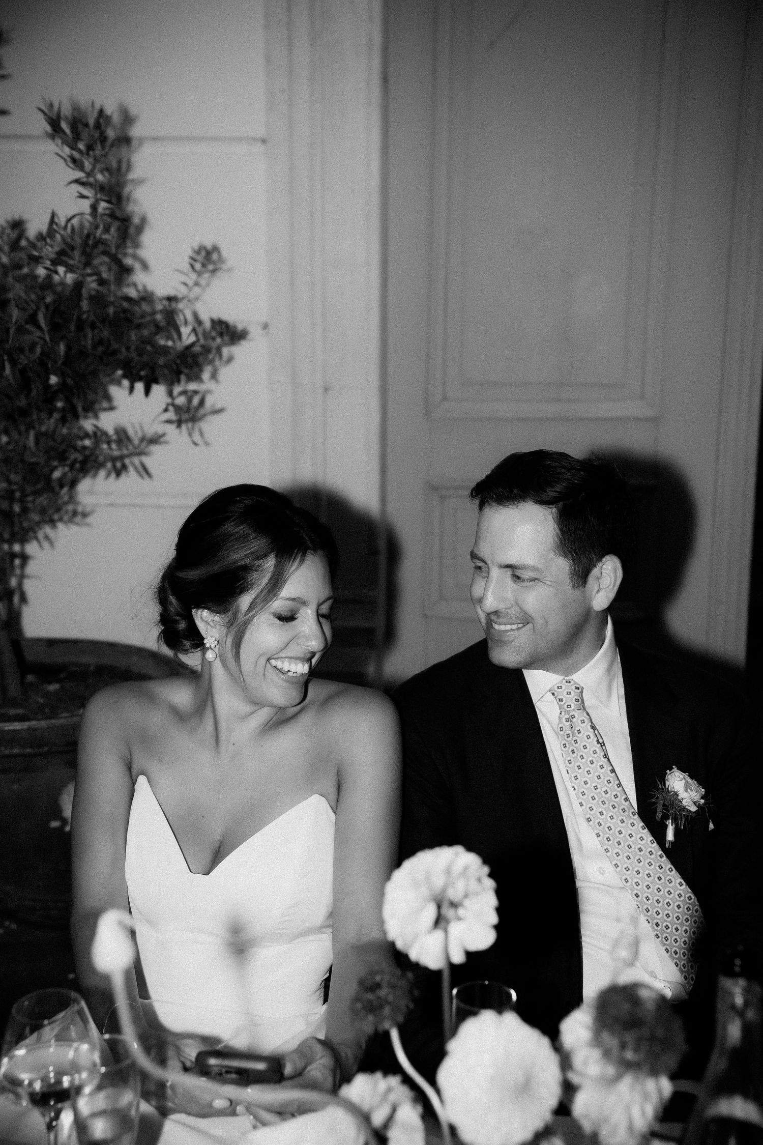 A couple shares a joyful moment together at an elegant dinner reception.