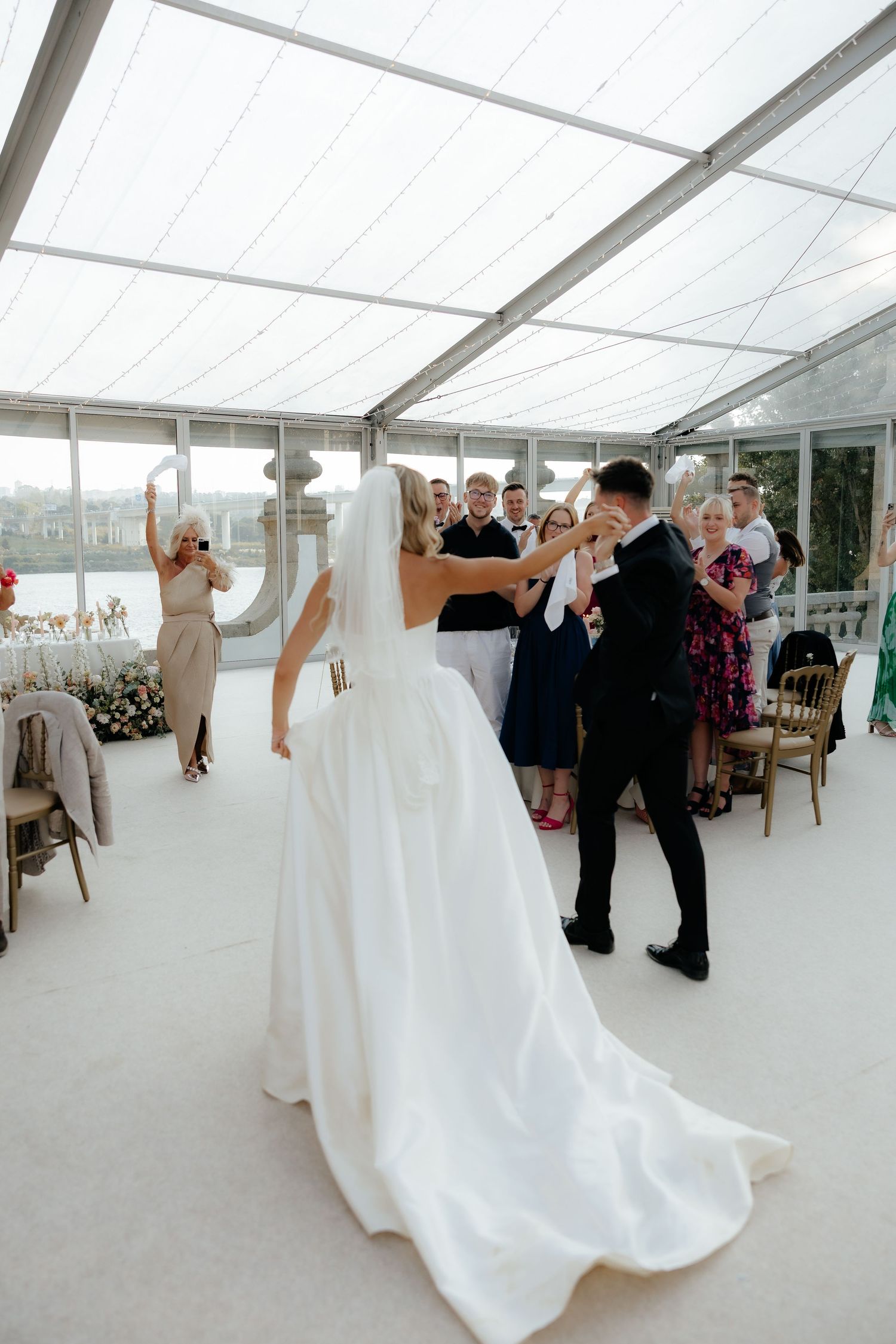 A sequence of wedding dance photos showing a couple twirling and moving across a bright reception tent.