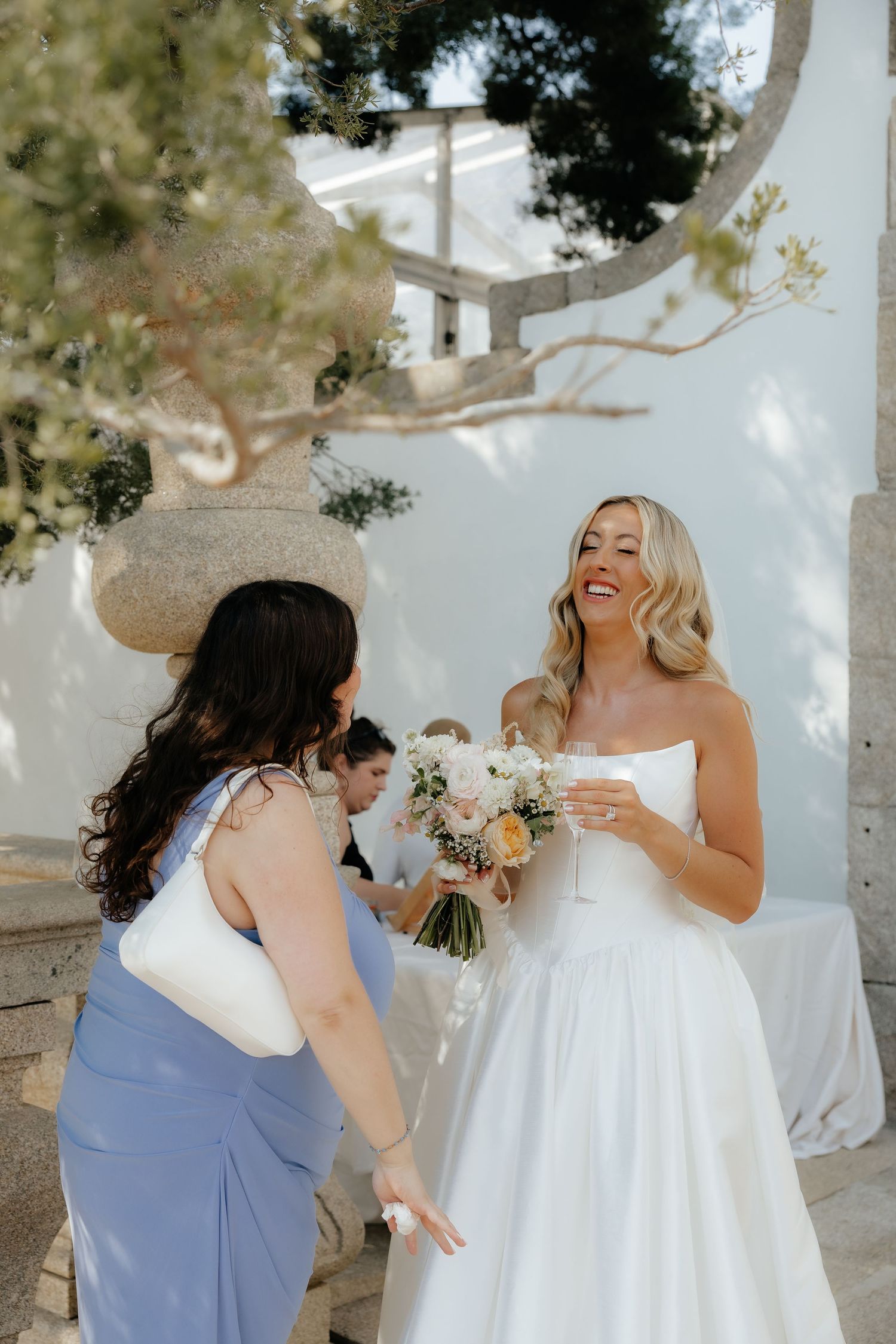 A sequence of candid moments showing bridesmaids in blue dresses helping adjust a bride's white wedding gown outdoors.
