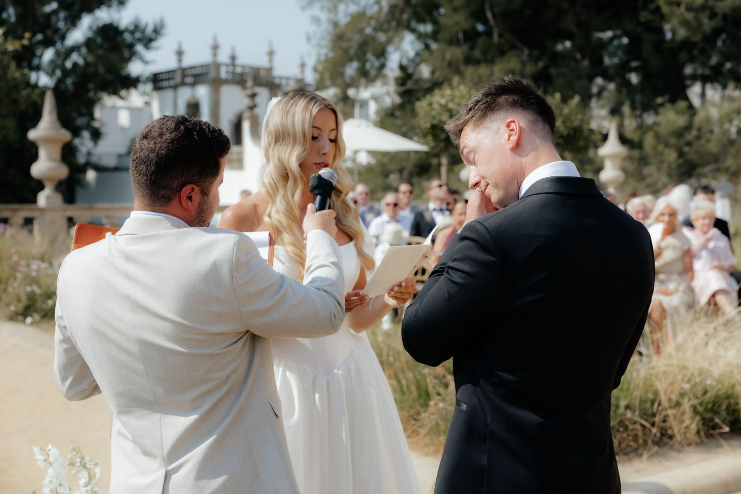 Wedding party members dance and celebrate during outdoor reception festivities.