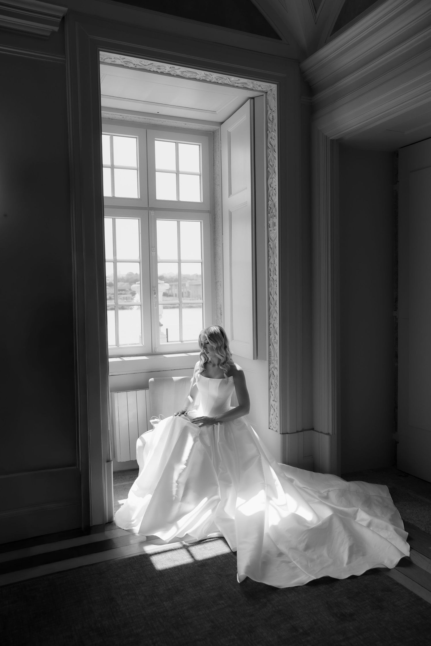 A dramatic black and white photo series showing a flowing white dress illuminated by natural window light in an empty room.