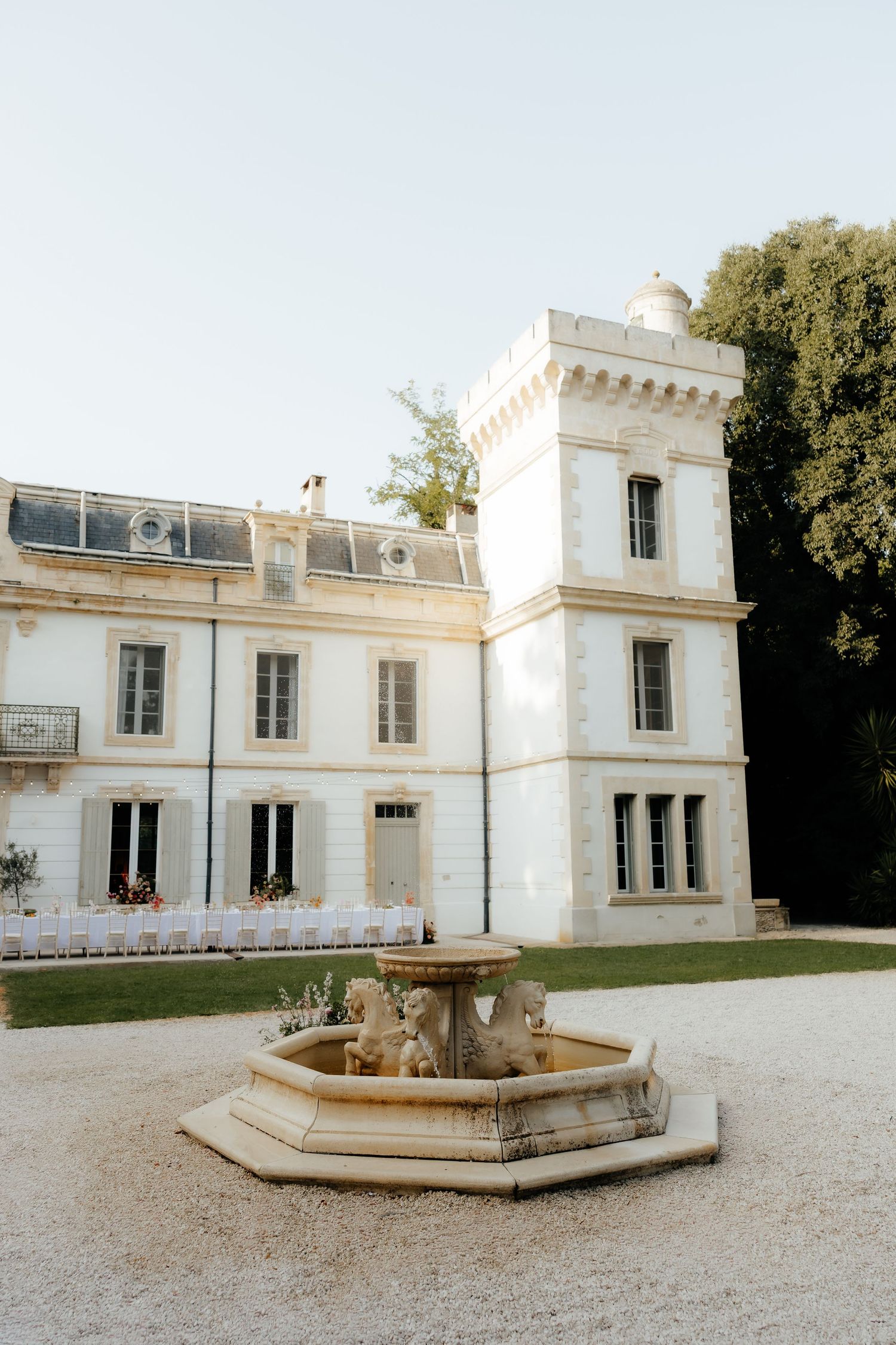 Elegant white neoclassical villa with fountain in courtyard shown from multiple angles in French countryside.