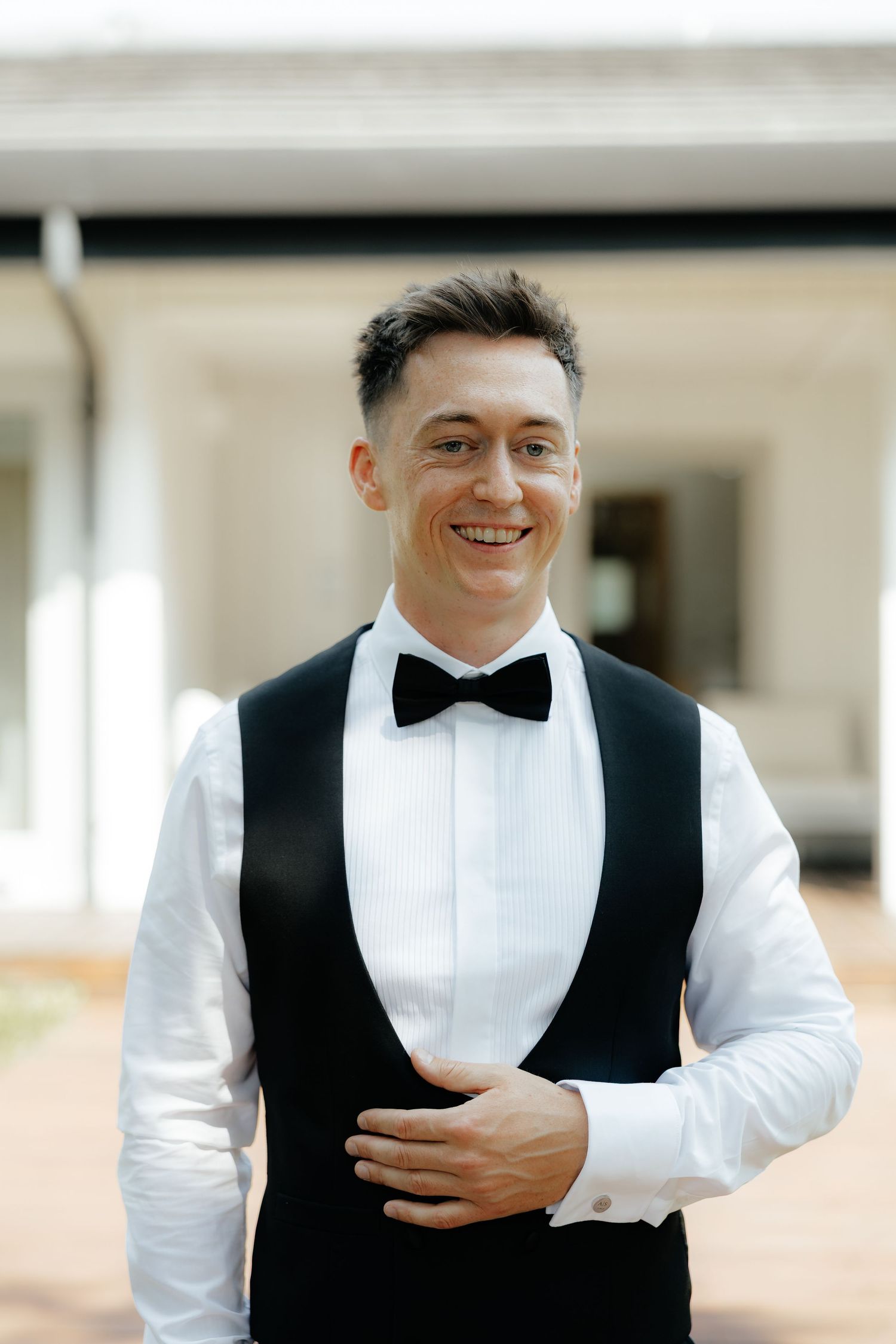A series of candid shots showing someone in formal attire with a black vest and bowtie smiling warmly at the camera.