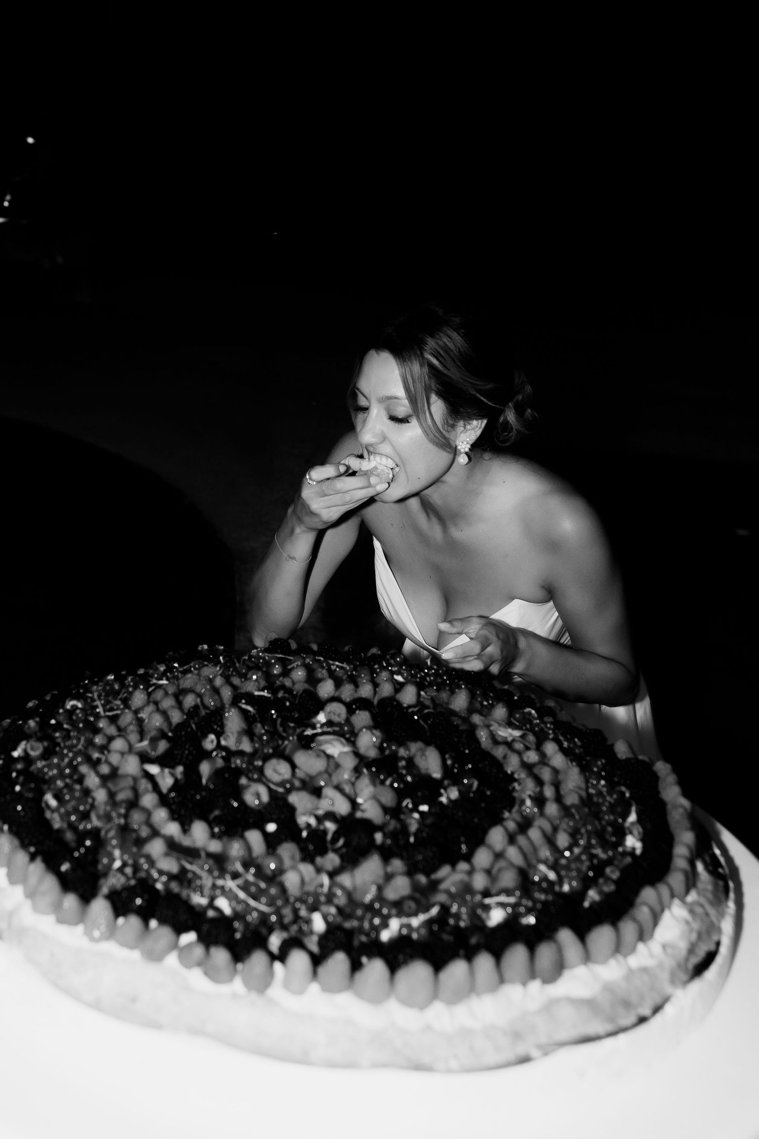 A sequence of black and white photos showing someone taking bites of a chocolate dessert topped with whipped cream.