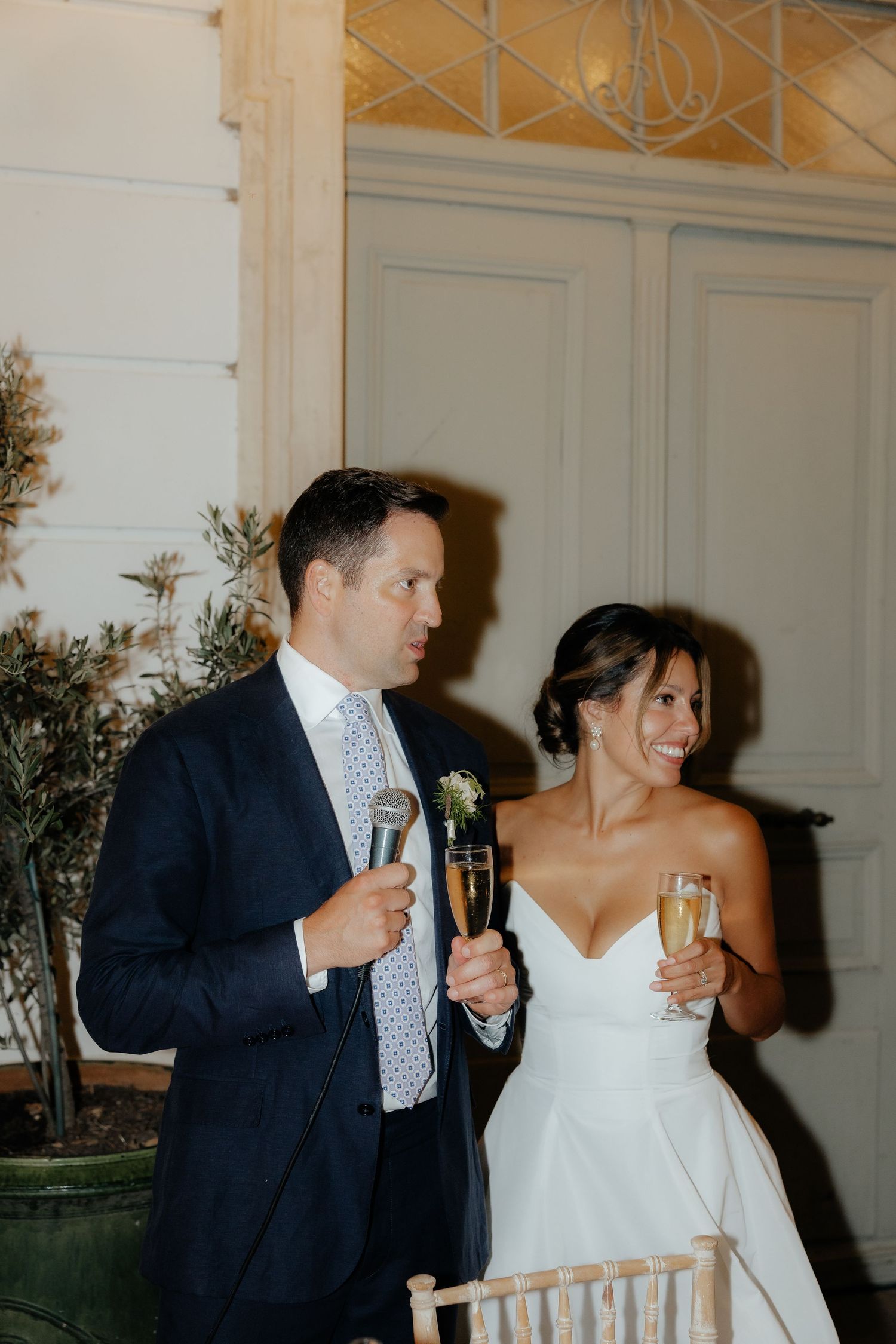 A couple toasting with champagne glasses at a formal celebration event.