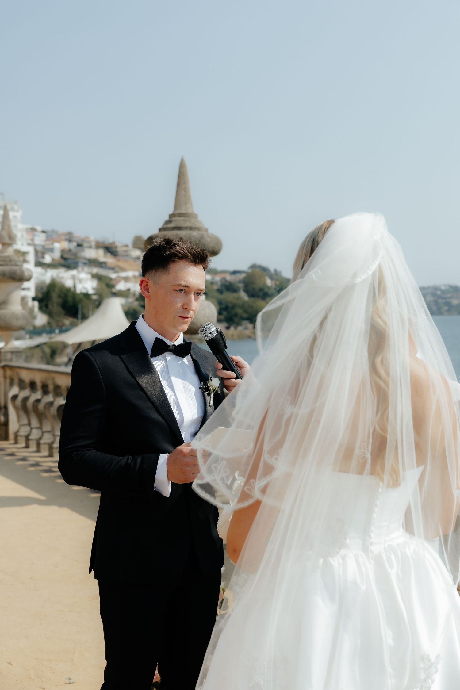 A bride and groom share an intimate moment during their wedding photoshoot by the ocean.