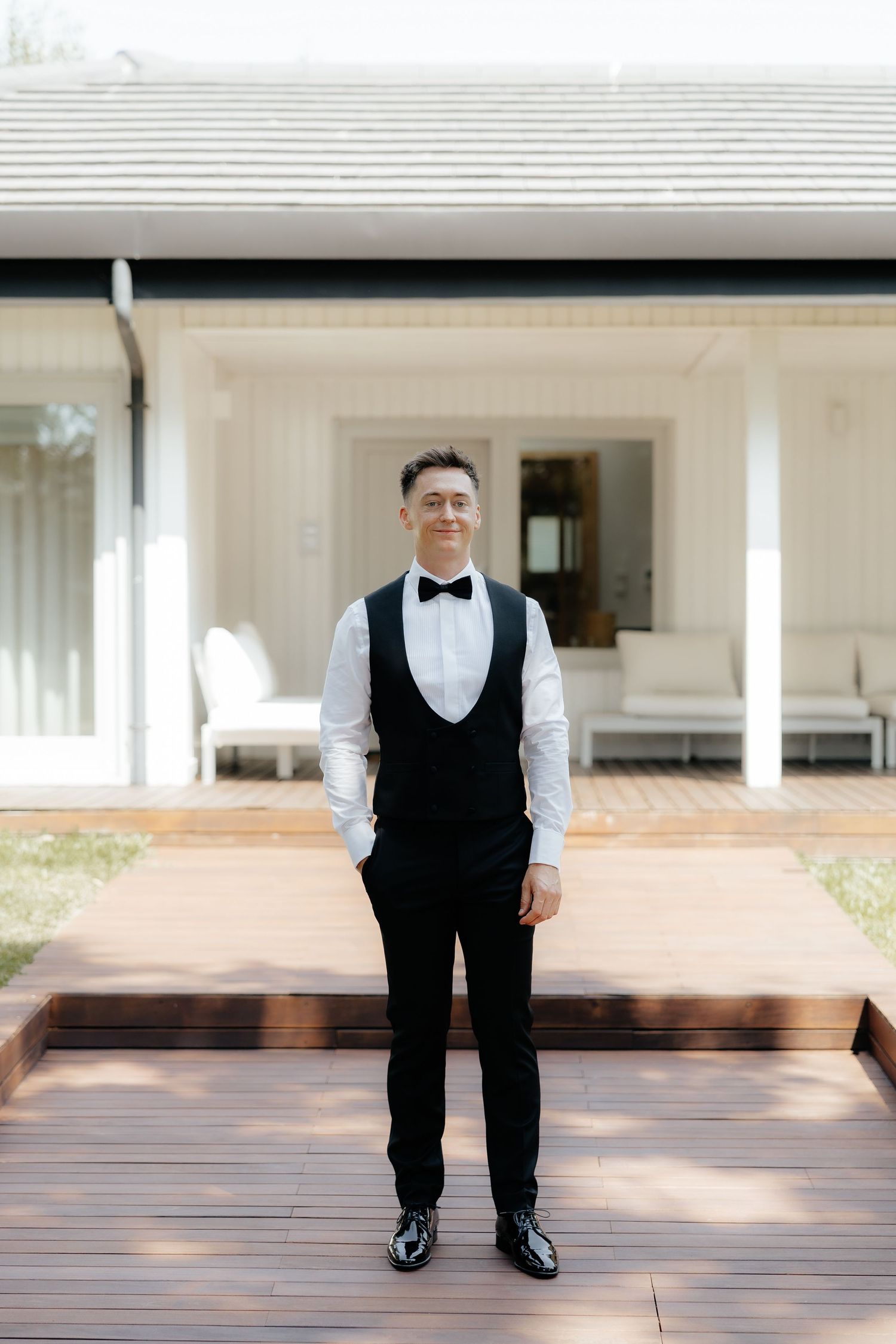 A person in formal black and white attire stands on a wooden deck in a panoramic sequence of photos.