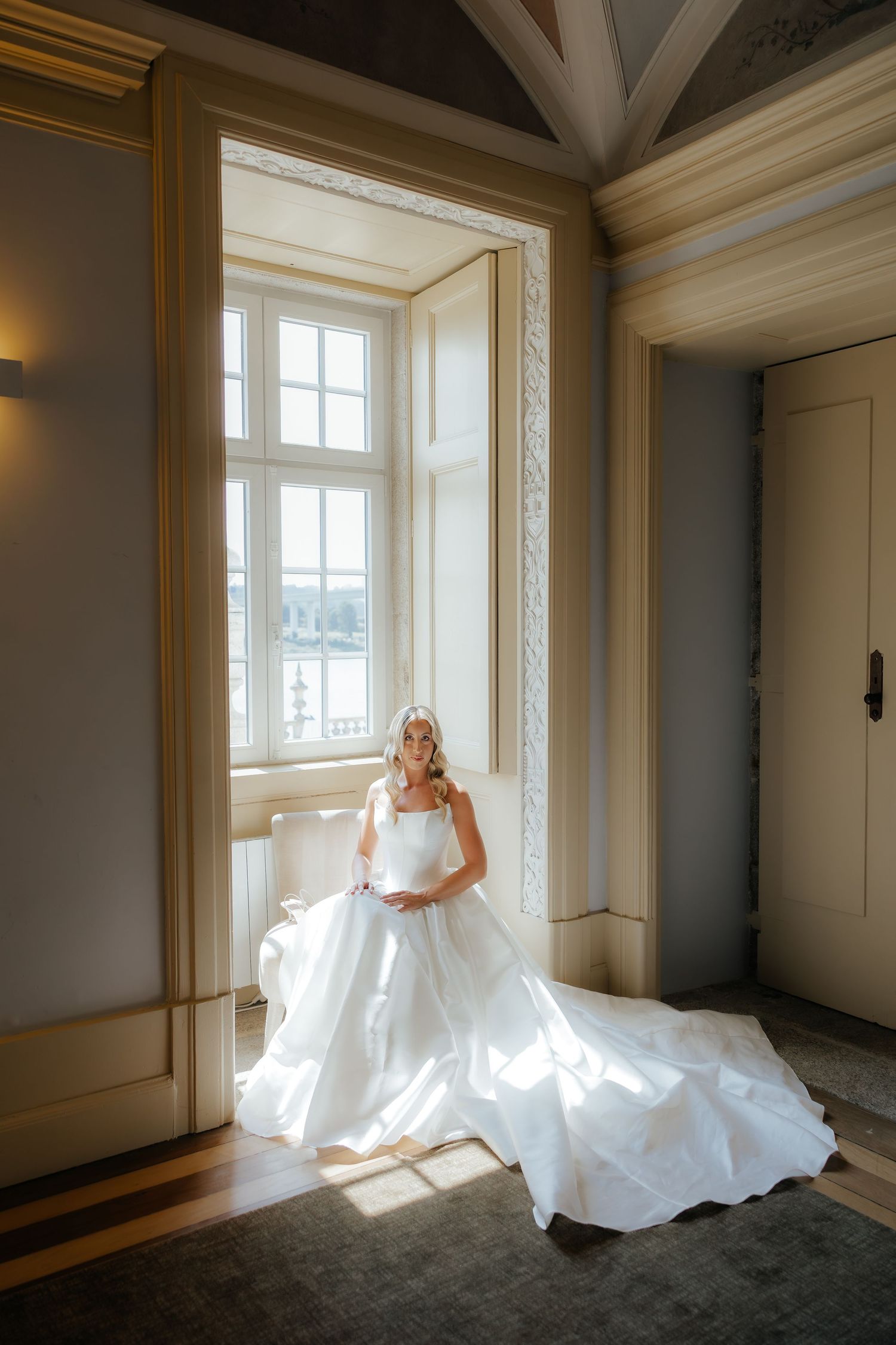 A series of wedding dress portraits in a sunlit room with white trim and dark floors showing elegant bridal poses.
