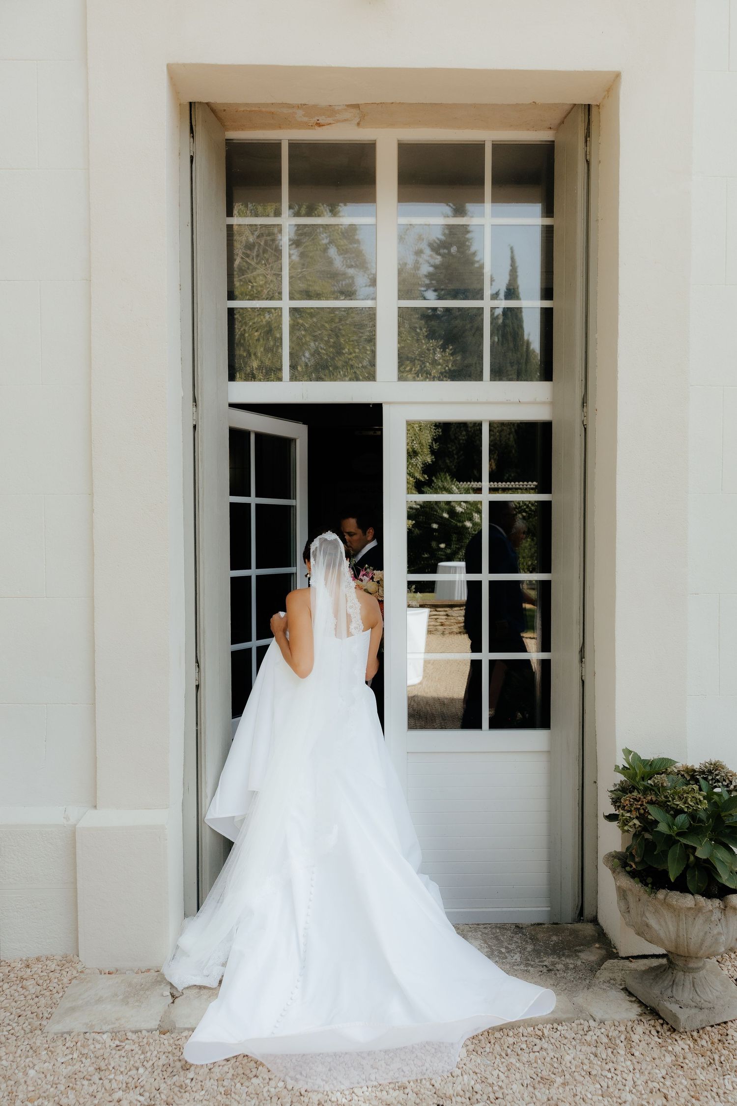 Wedding dress silhouette sequence against white building exterior with large windows.
