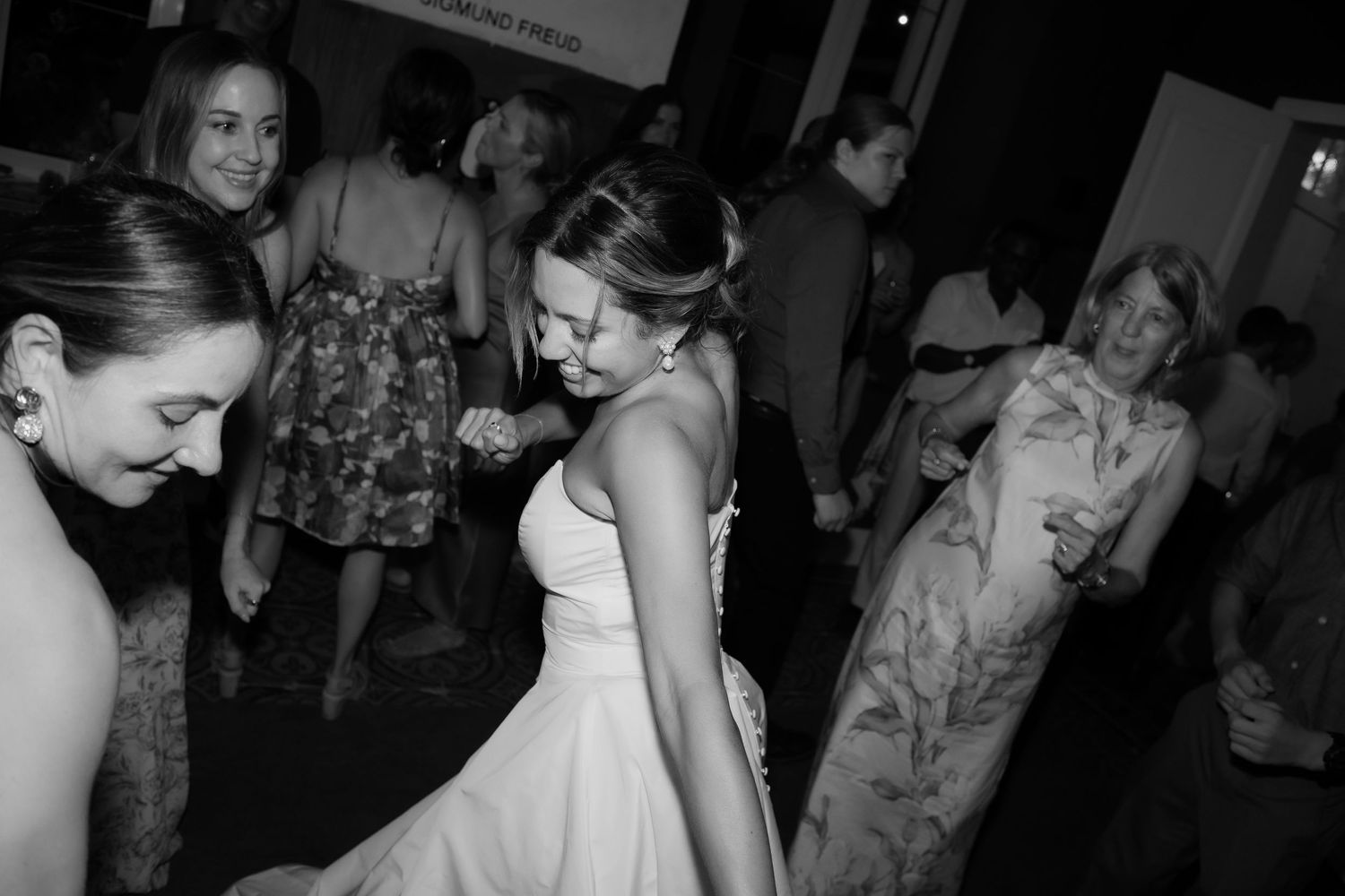 A couple shares a romantic dance together at a dimly lit wedding reception.