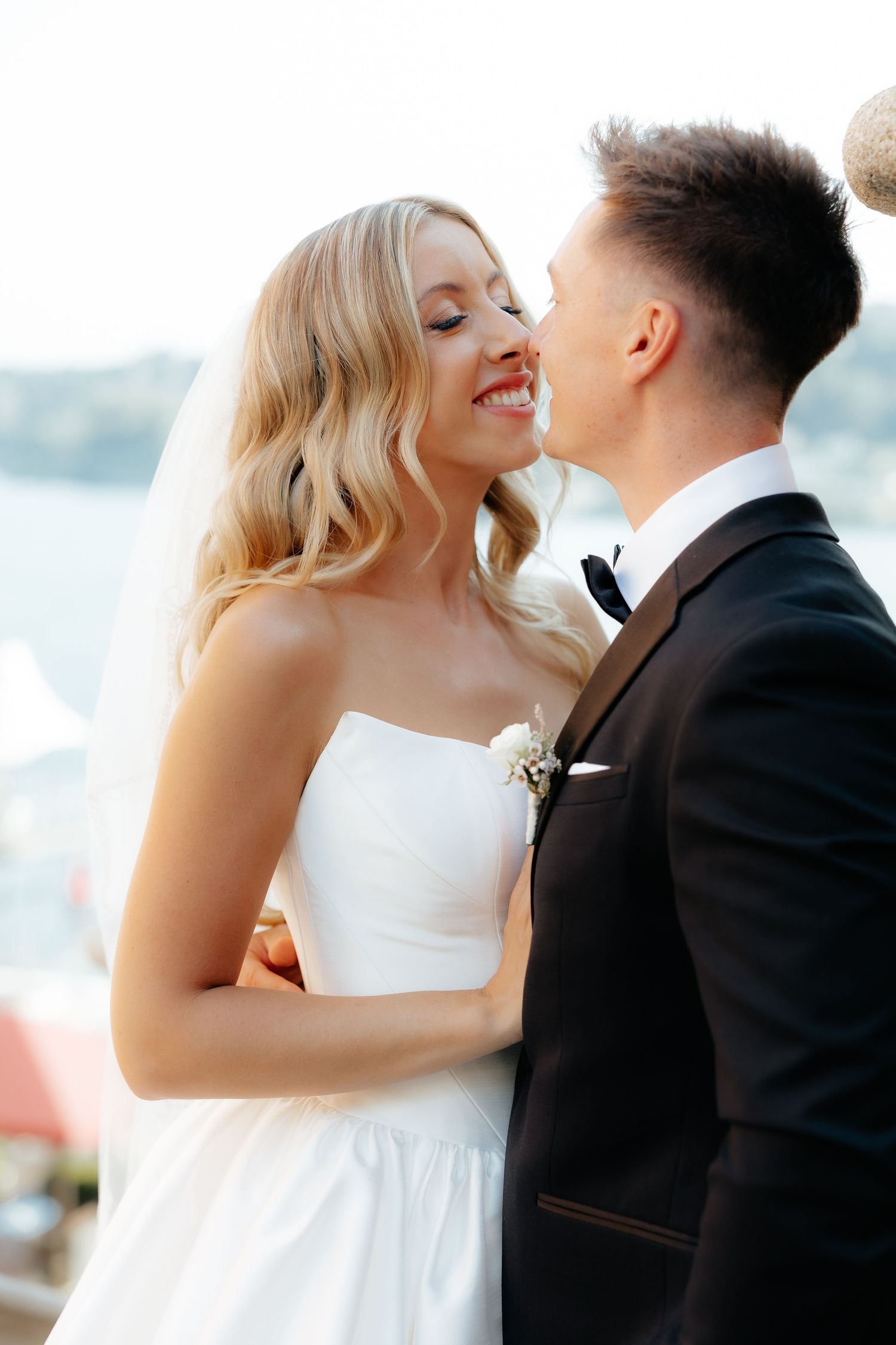 A romantic wedding couple shares tender kisses in a series of intimate outdoor portrait photographs.