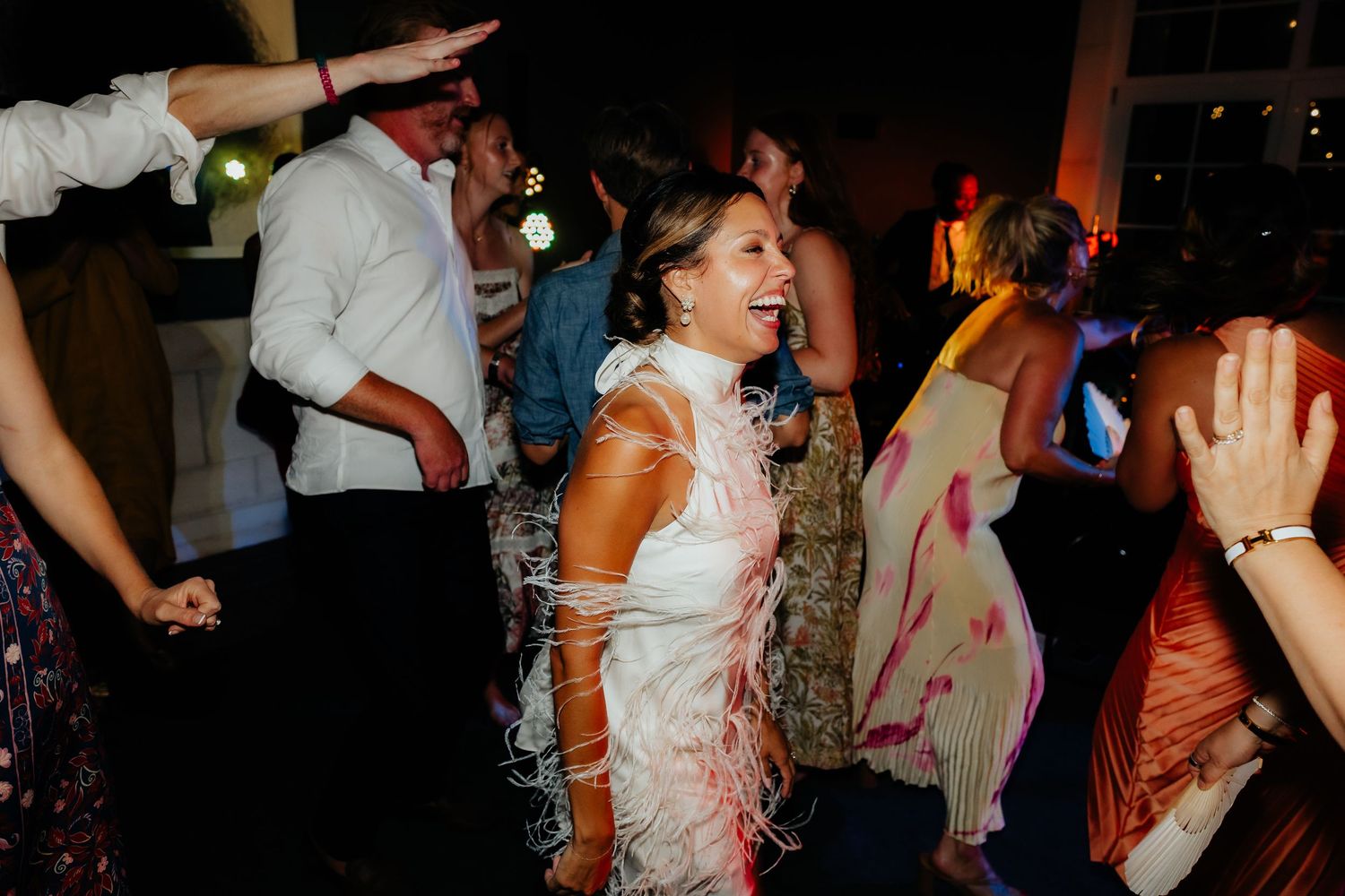 Guests dancing and having fun at a lively wedding reception party.