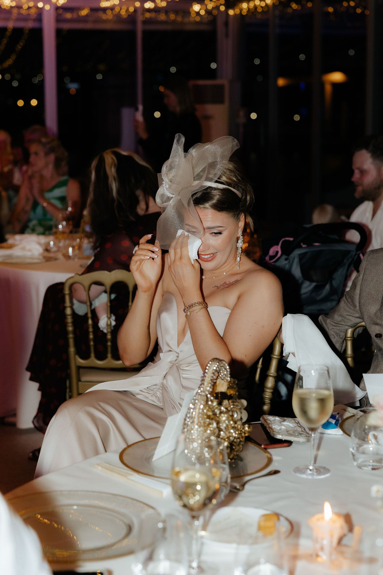 A sequence of four candid moments at a wedding reception dinner table with elegant place settings and glowing candlelight.