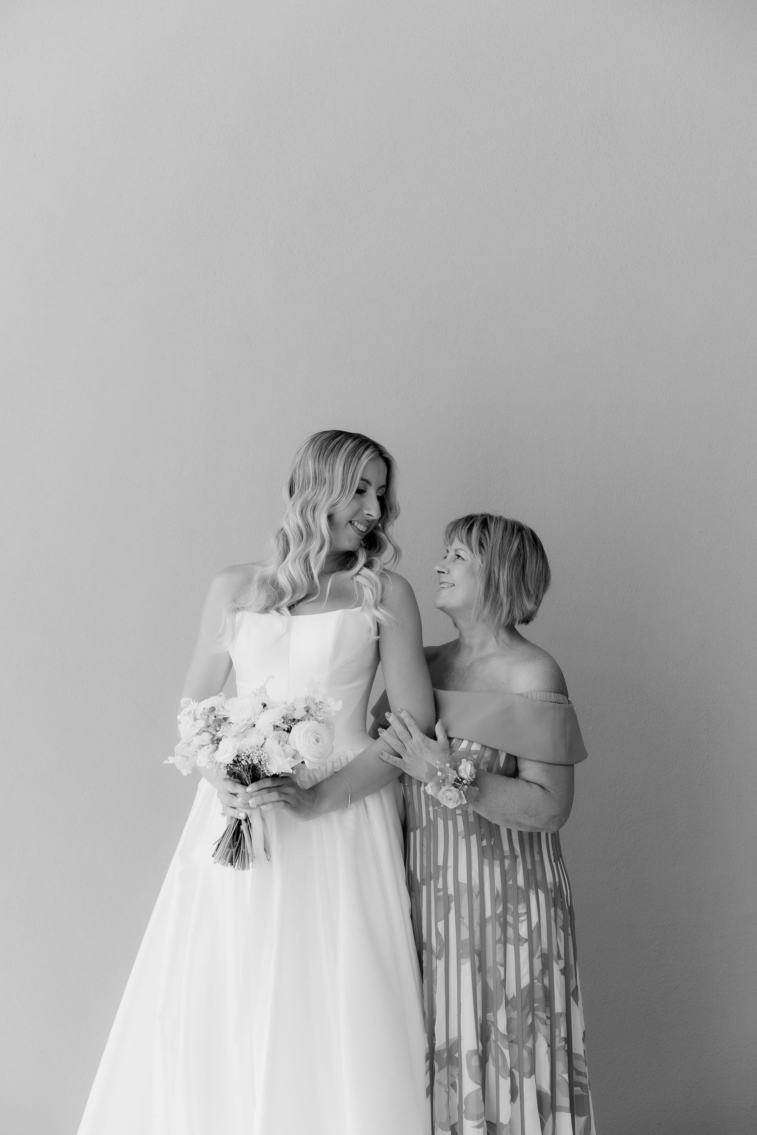 Black and white artistic wedding photography series showing tender emotional moments between bride and mother in matching gowns.