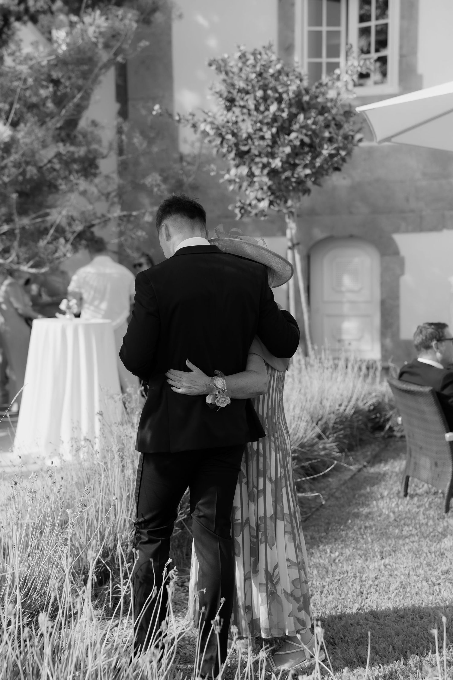 A sequence of black and white photos showing someone bending down to examine something in a grassy area near a building.