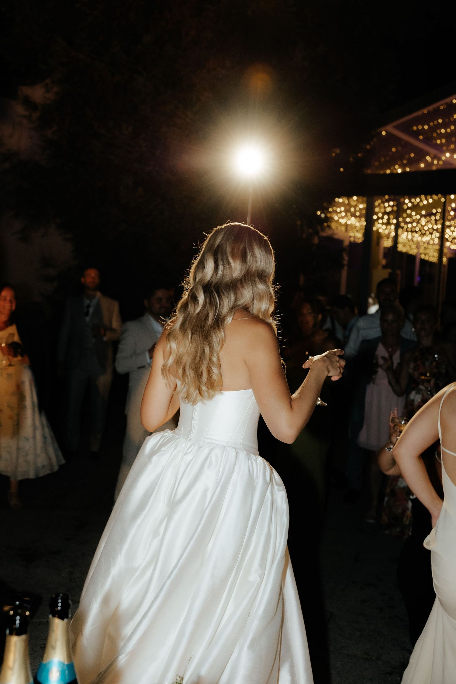 A sequence of photos shows a person in a white dress dancing at a nighttime party under string lights.