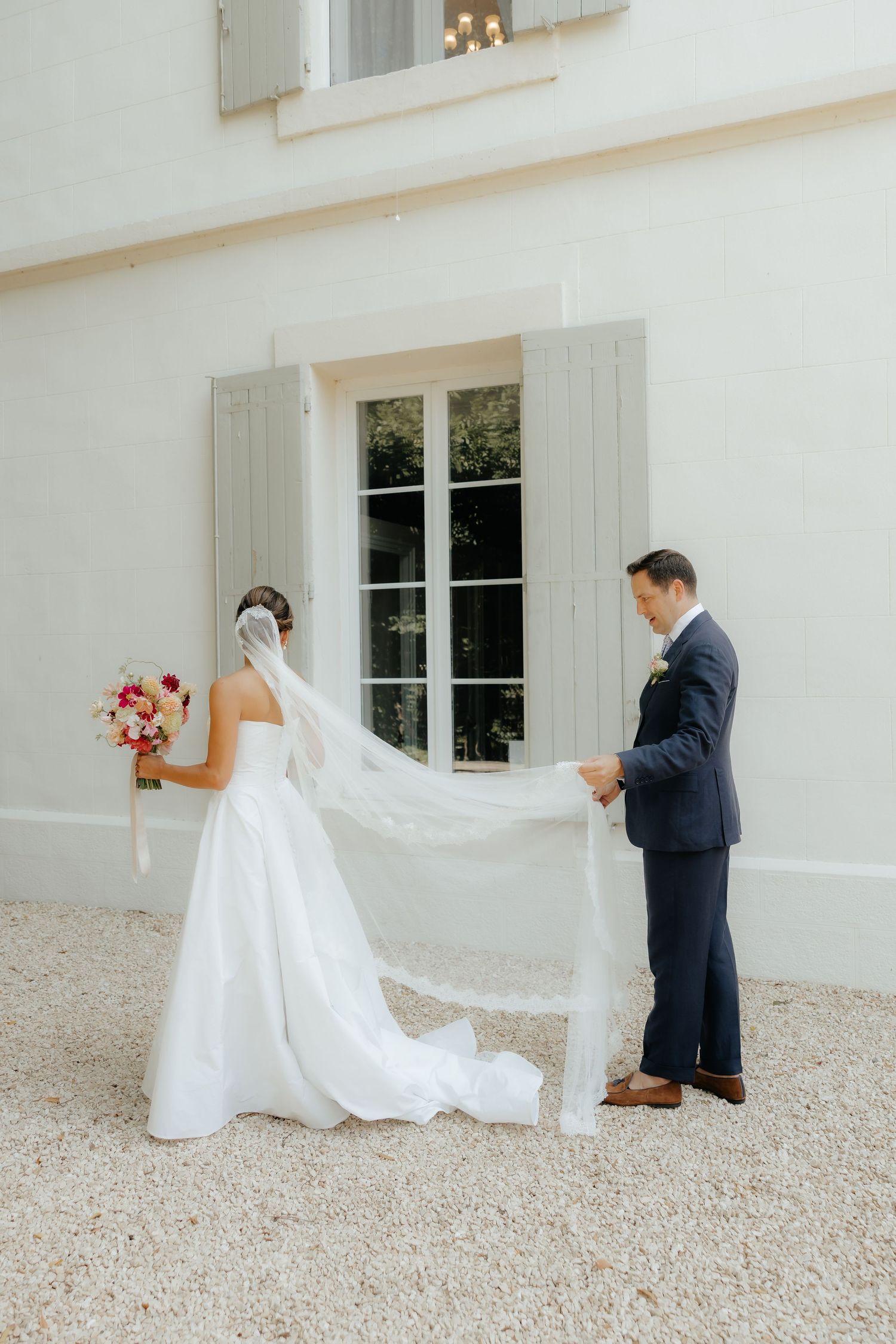 Playful wedding photo sequence showing couple peeking around white building corner.