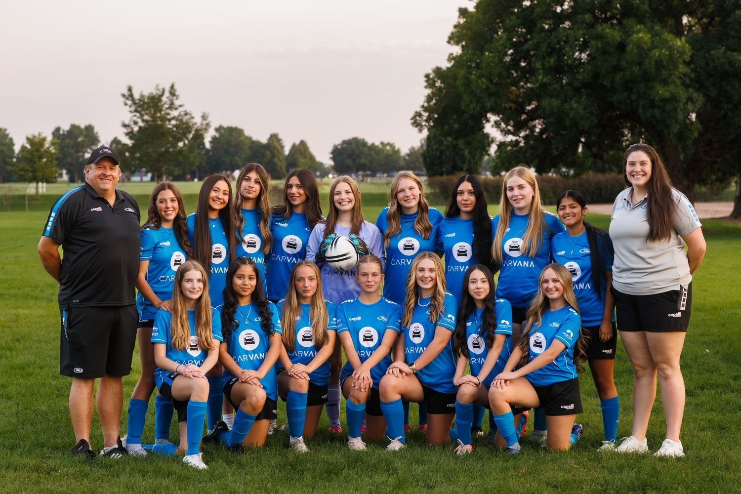 NORCO Rush girls high school team, posing together on a field with their coaches