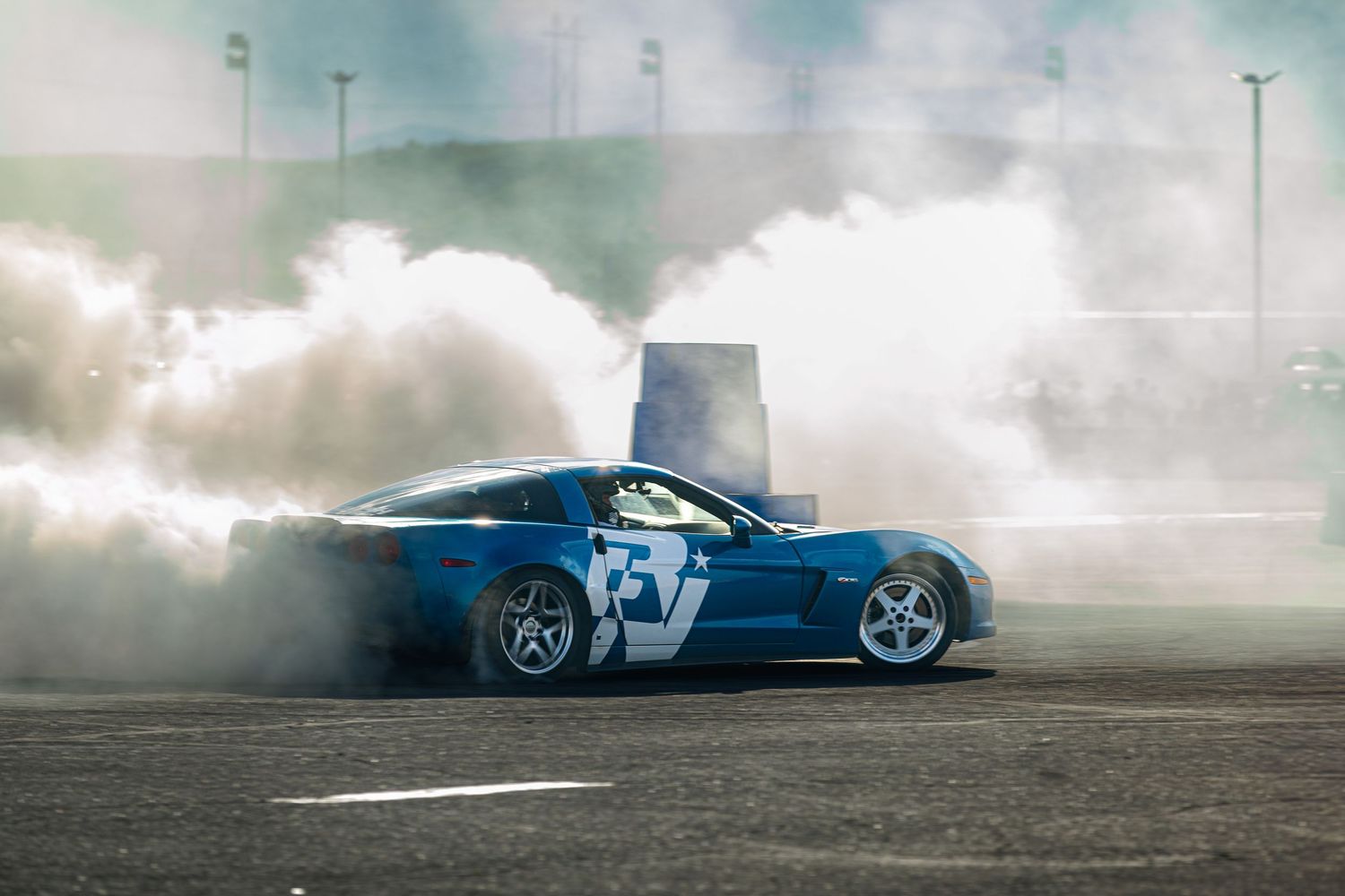 Blue C6 Corvette, drifting at Pikes Peak international Raceway, leaving behind huge clouds of smoke