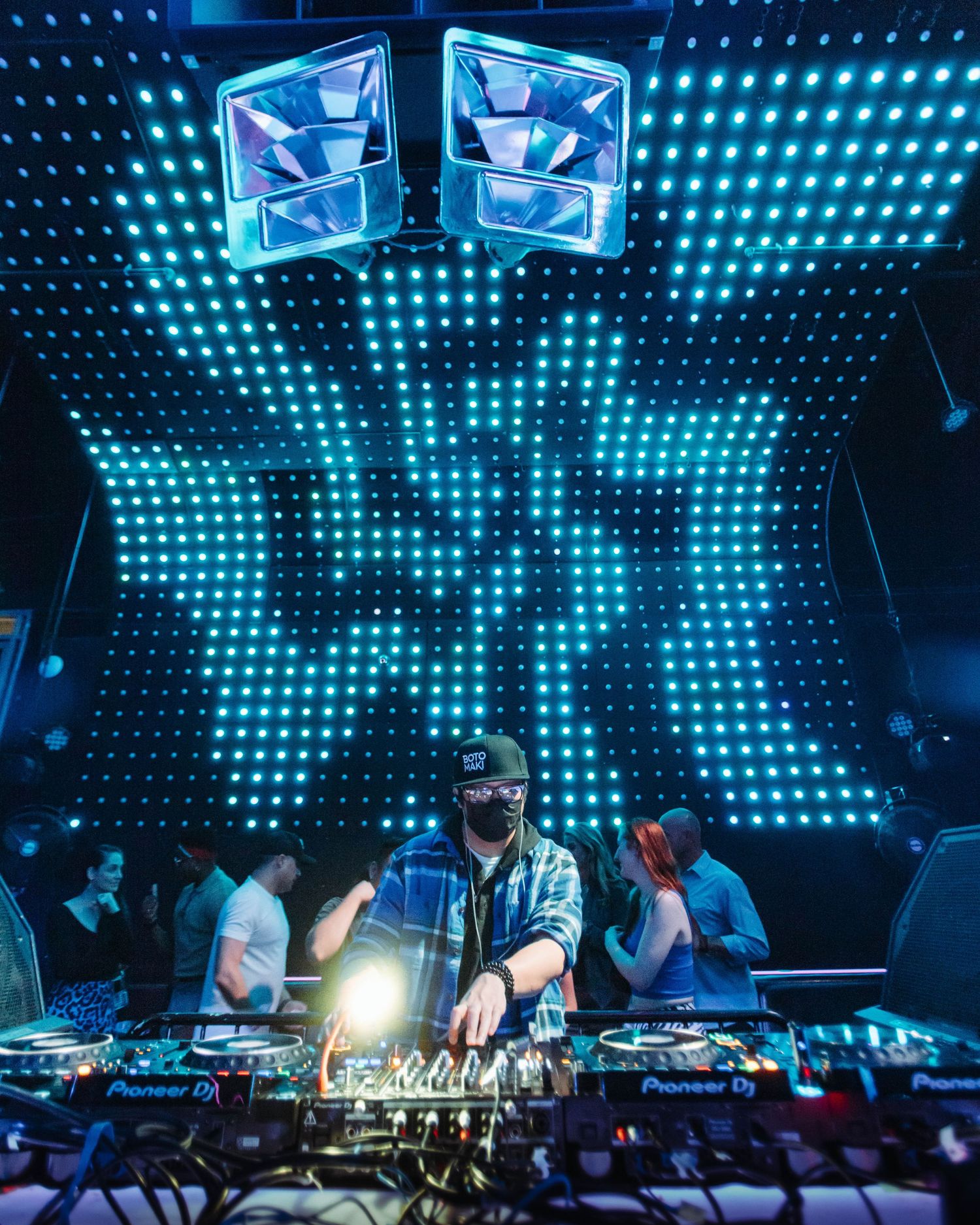 Wide angle shot of DJ Botomaki, in front of vfx light wall at Club Vinyl in downtown Denver.